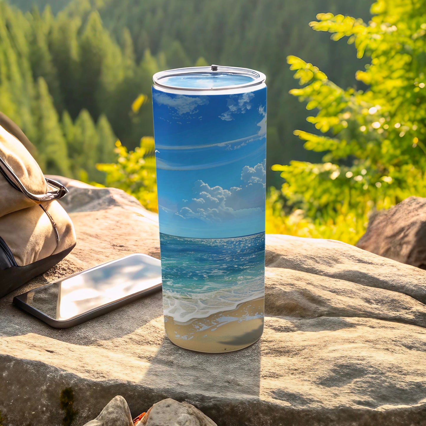 Beach scene tumbler on rock with backpack and phone.