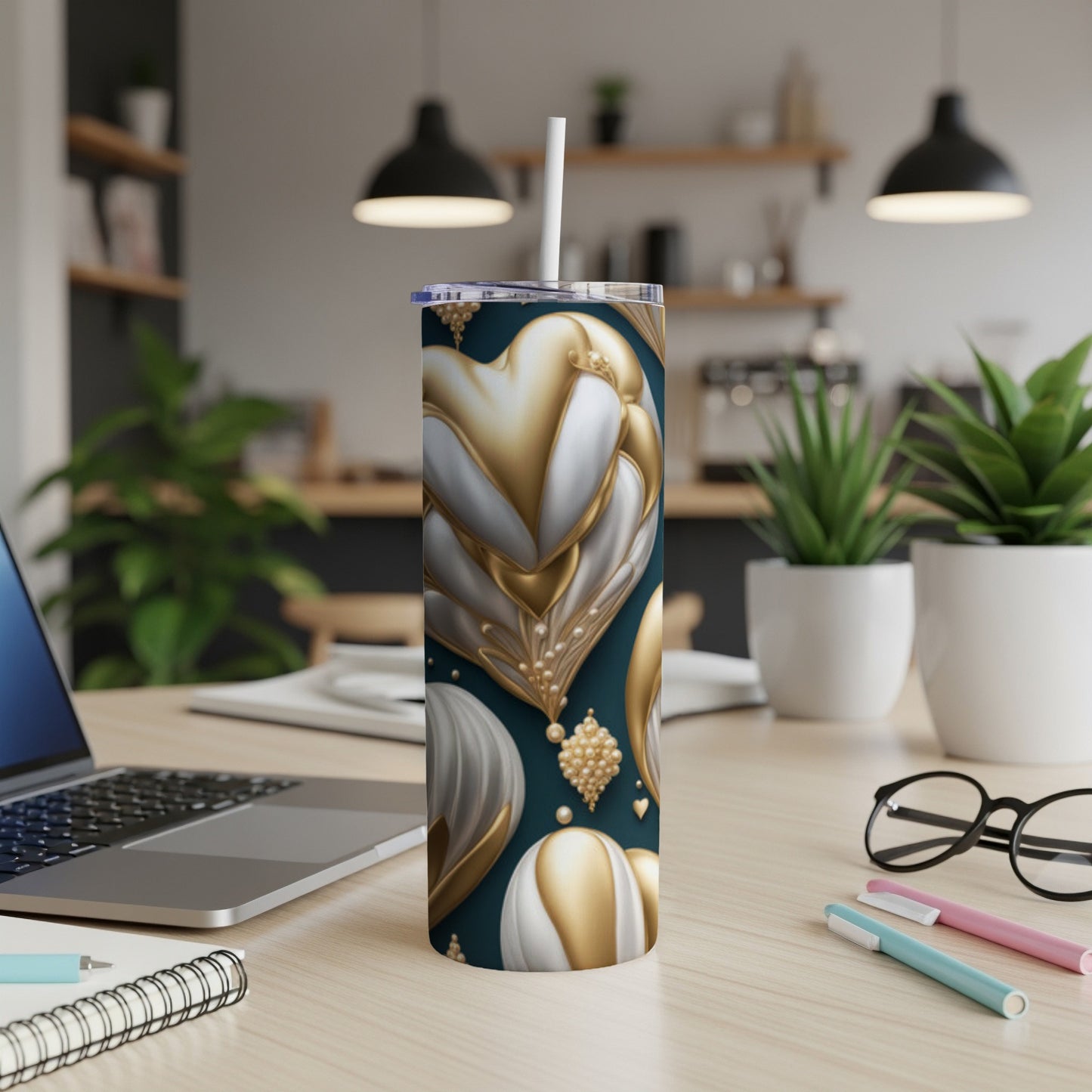 Gold and white heart pattern tumbler with straw on a desk.