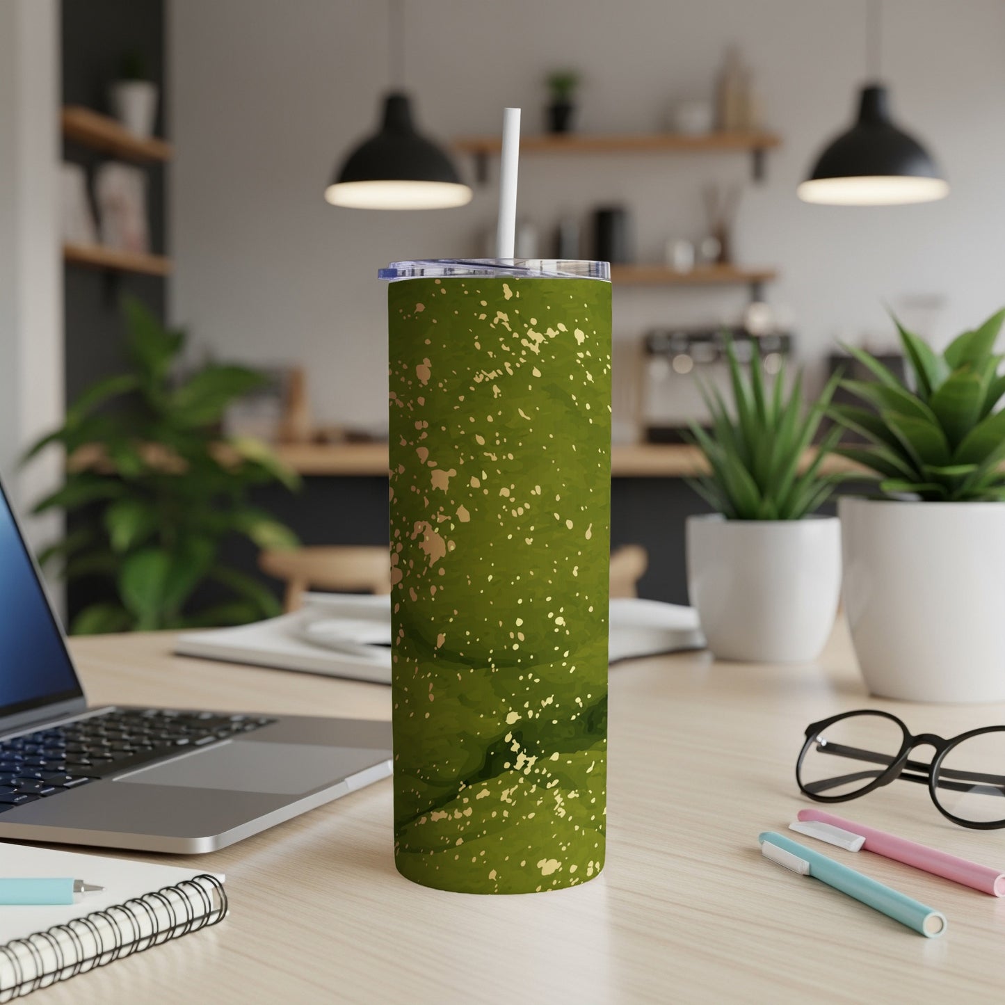 Green abstract splatter tumbler with white lid and straw.