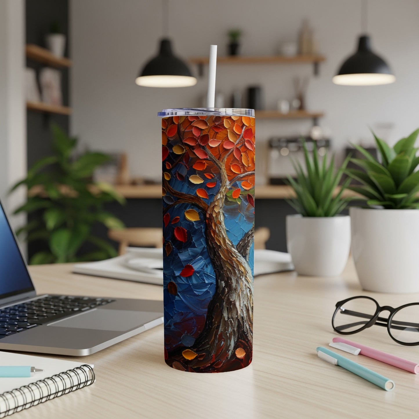 Oil painting of a vibrant autumn tree with falling leaves on a desk.