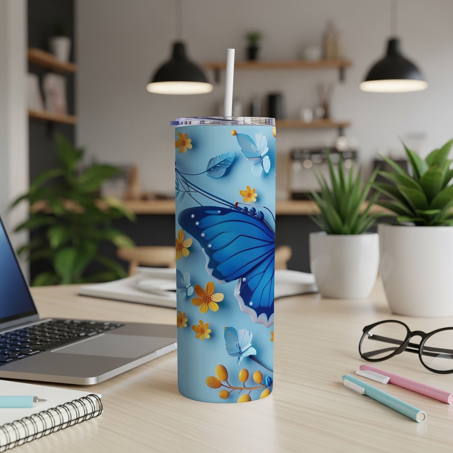 Blue butterfly and floral pattern on a light blue stainless steel tumbler.