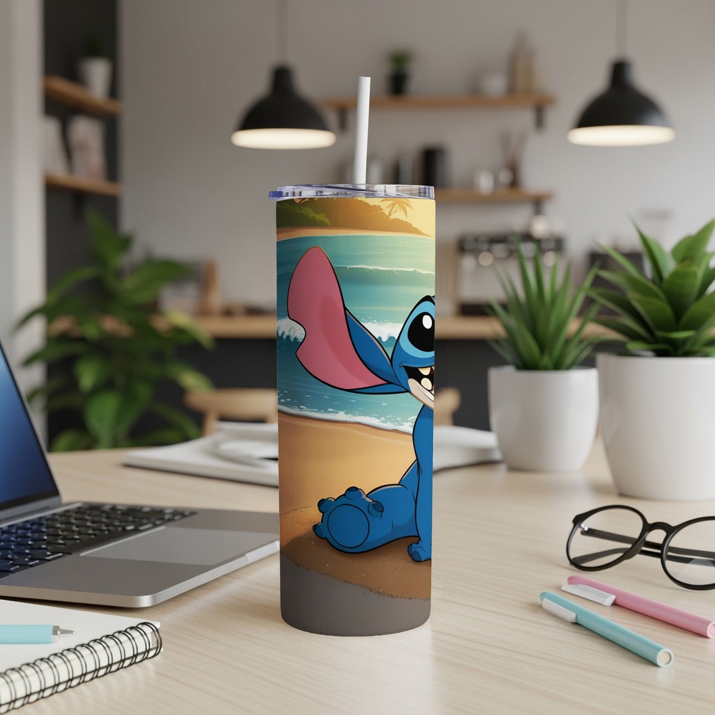 Stitch character on a beach, sitting on a desk with a laptop and glasses.