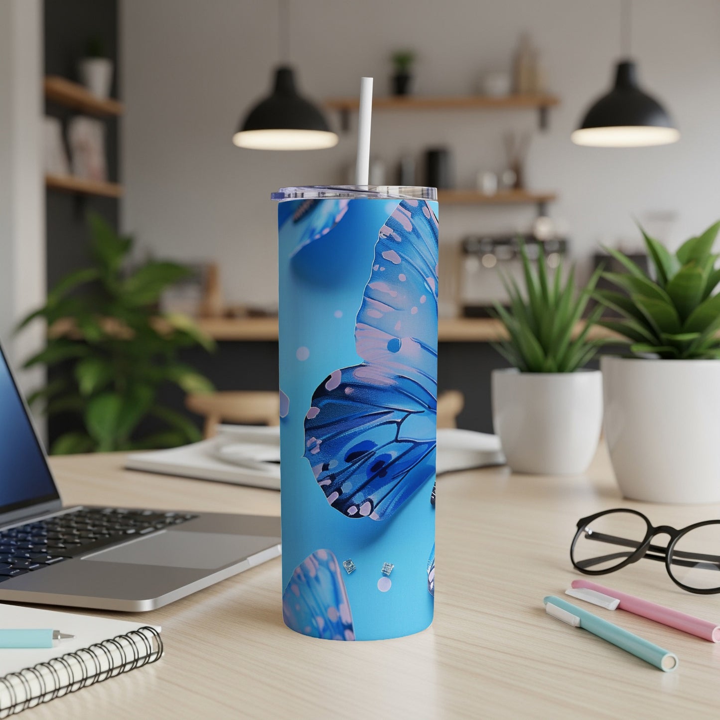 Blue butterfly pattern on a stainless steel tumbler with a straw.