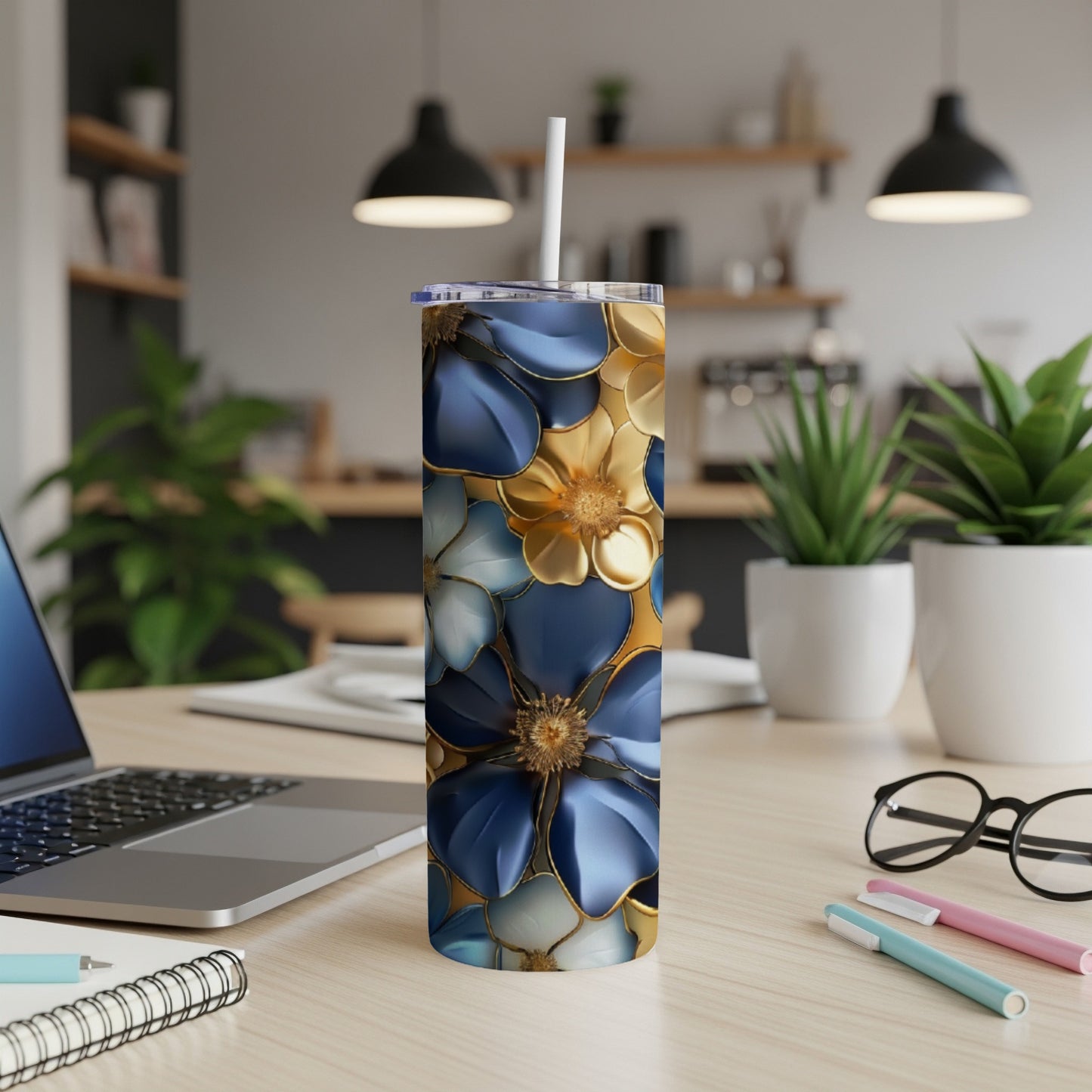 Blue and gold floral pattern on a white tumbler with a straw.