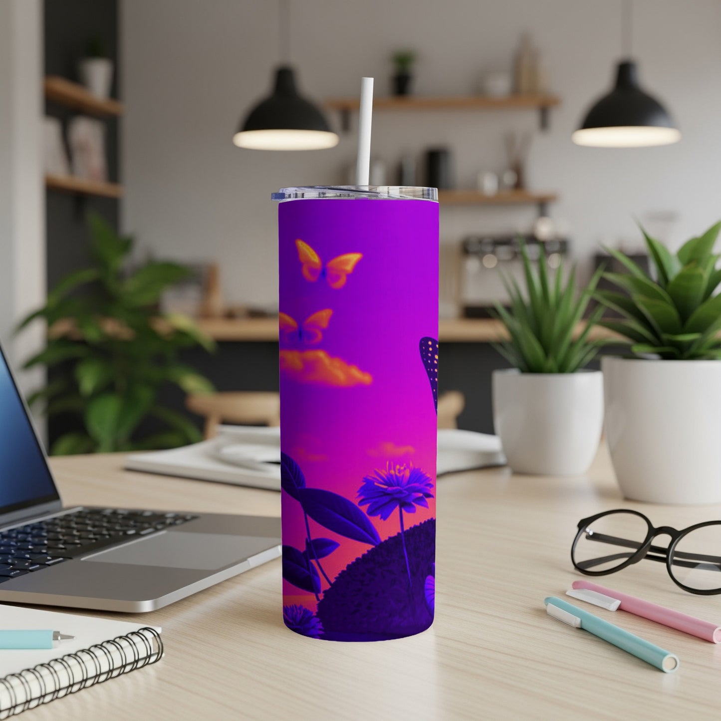 Purple tumbler with butterfly and flower design on desk.