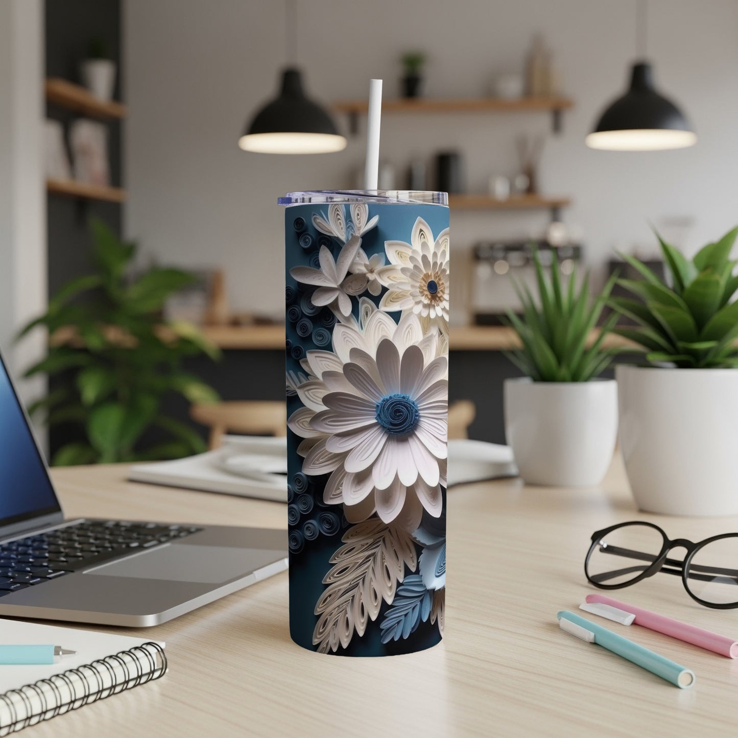 Blue and white floral tumbler with straw on a desk.