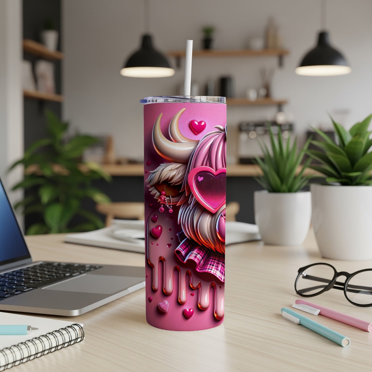 Pink tumbler with hearts, fluffy ears, and plaid pattern, on a desk.