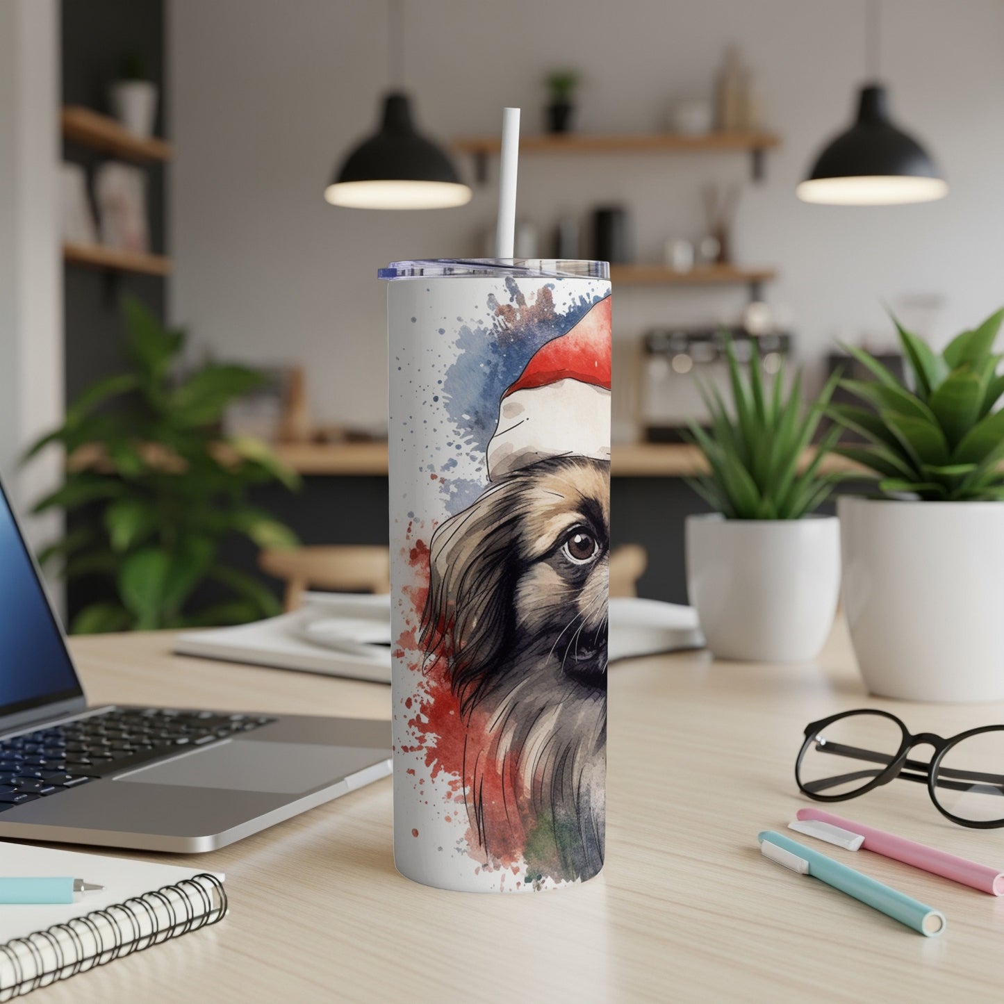 Tumbler with watercolor dog wearing Santa hat, on a desk.