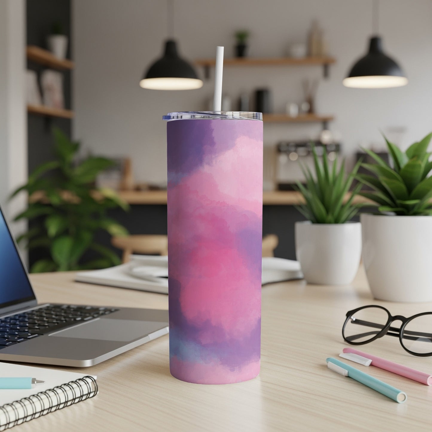 Tall tumbler with pink and purple watercolor design and white straw.