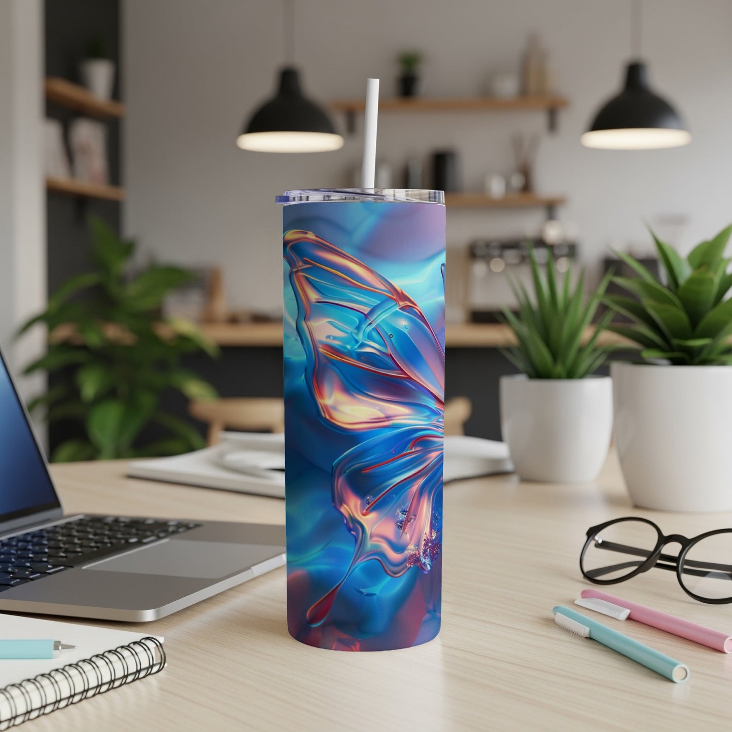 Iridescent butterfly tumbler on a desk with a laptop and pens.