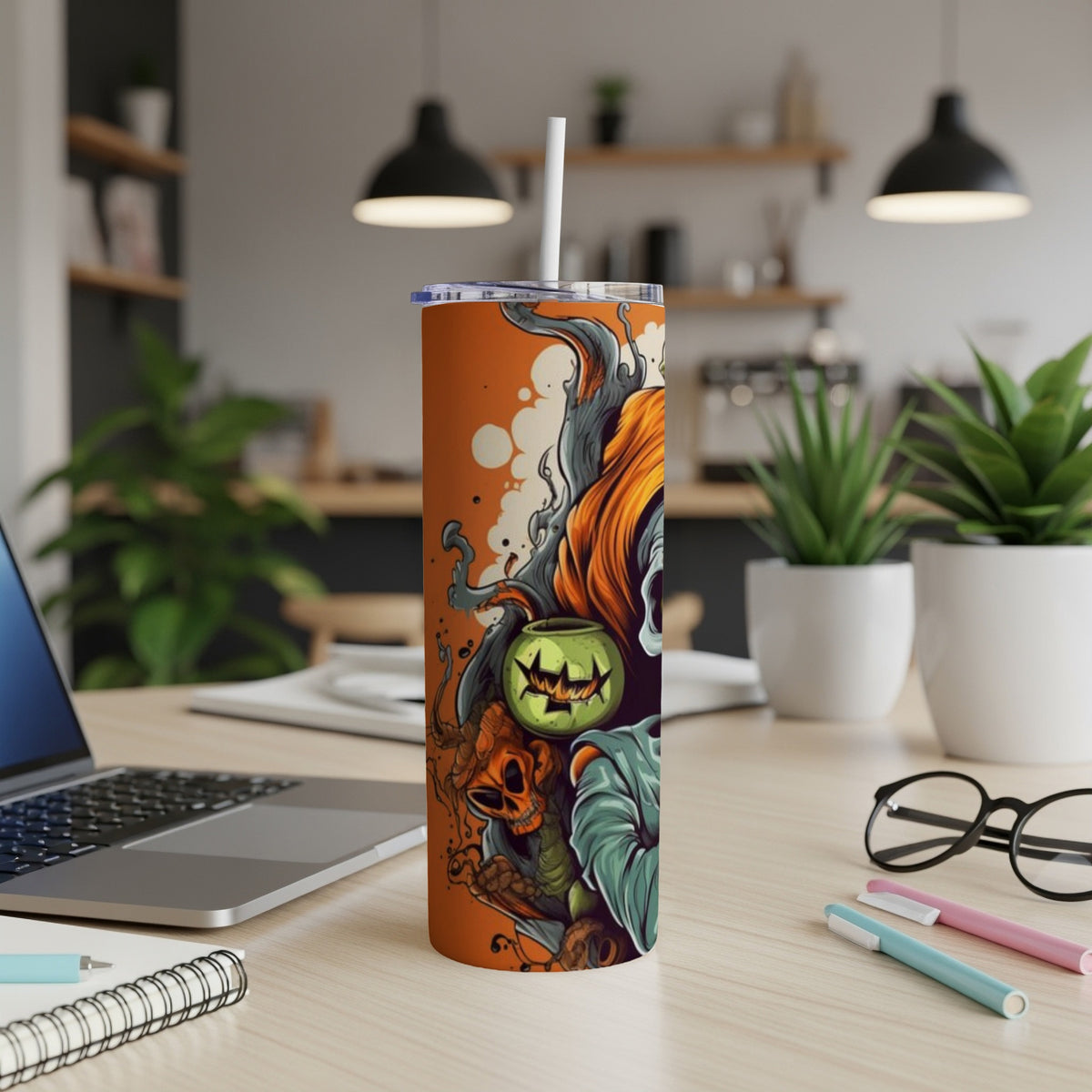 Orange tumbler with a scary Halloween-themed illustration of a pumpkin and skeleton.