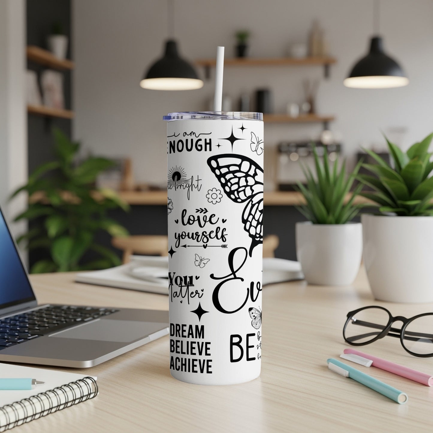 White tumbler with black butterfly and motivational text.