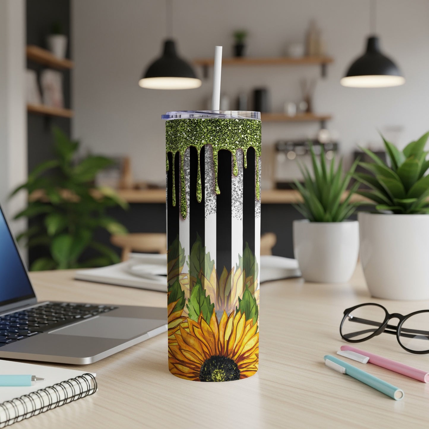 Black and white striped tumbler with glittery green drip and sunflower at bottom.