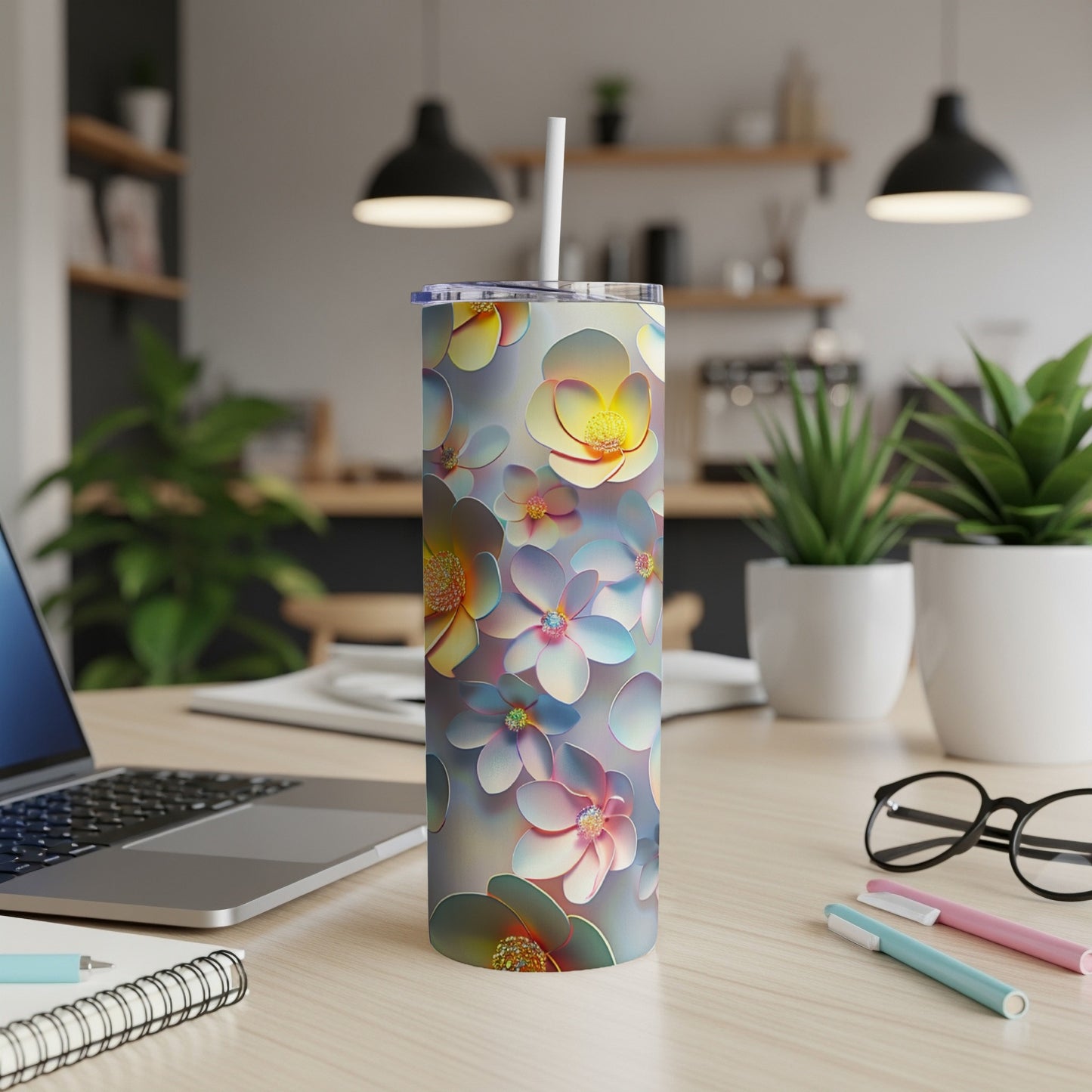 Floral patterned tumbler with straw on a desk.