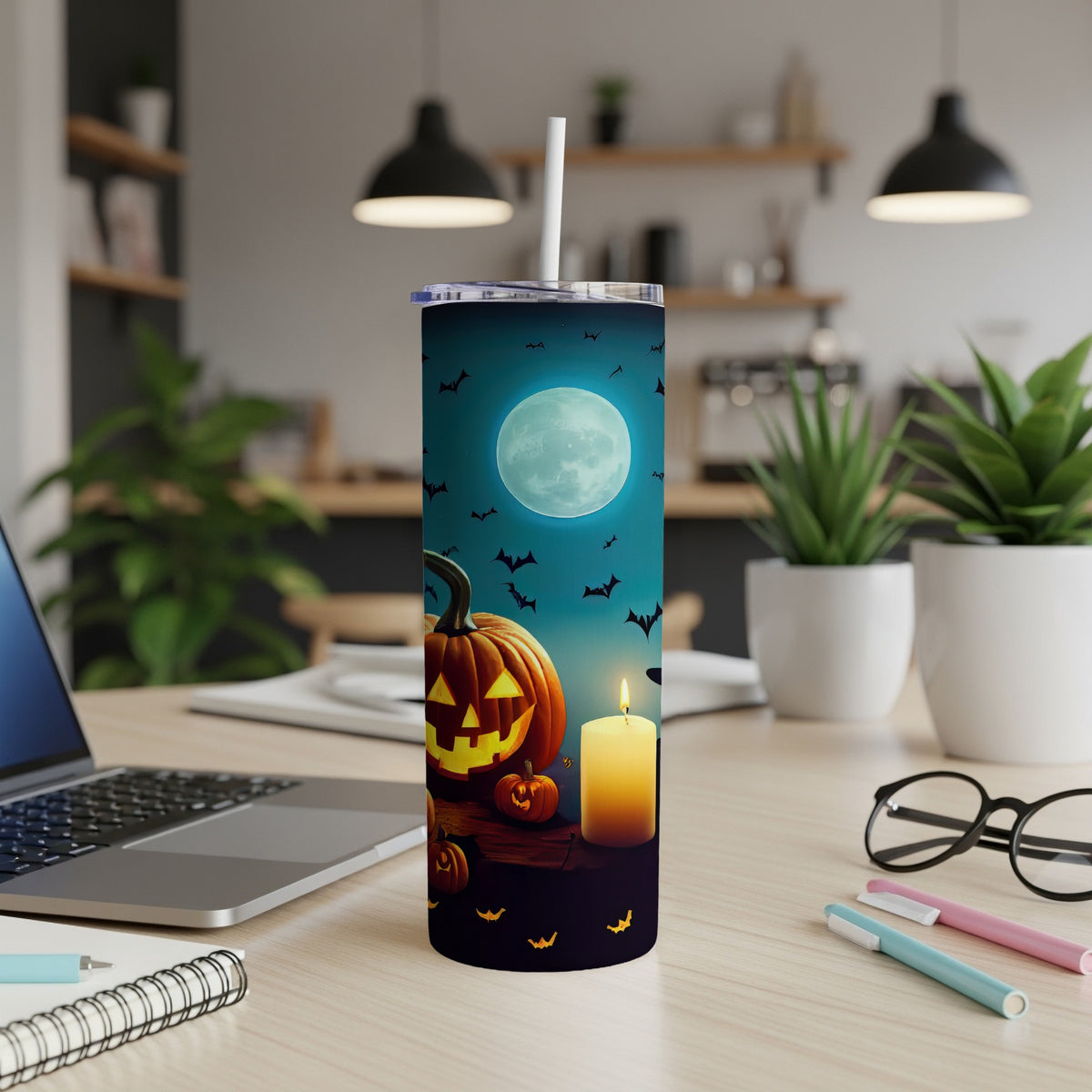 Halloween tumbler with pumpkins, bats, and a full moon under a teal sky.
