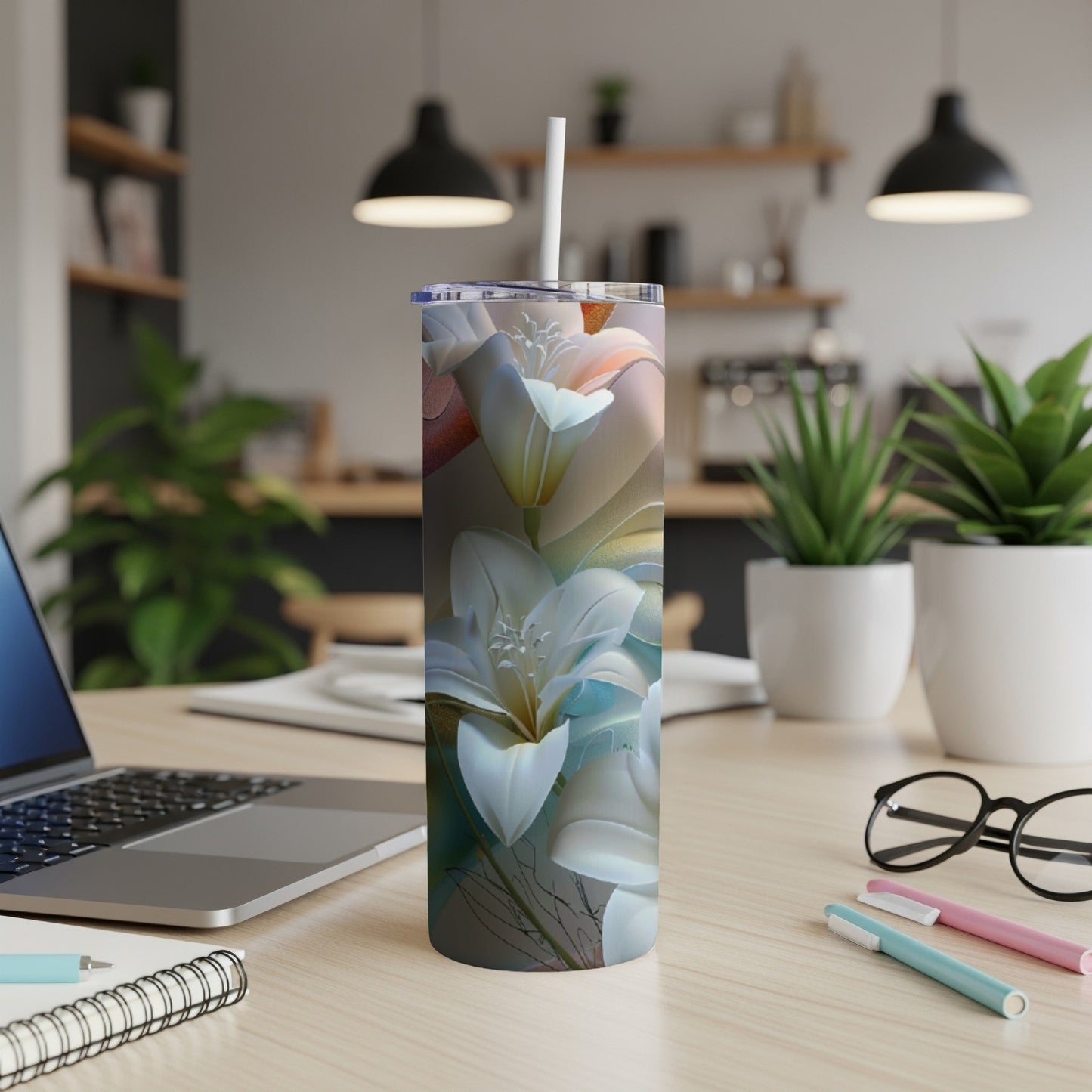 Tall tumbler with a floral pattern on a desk next to a laptop.