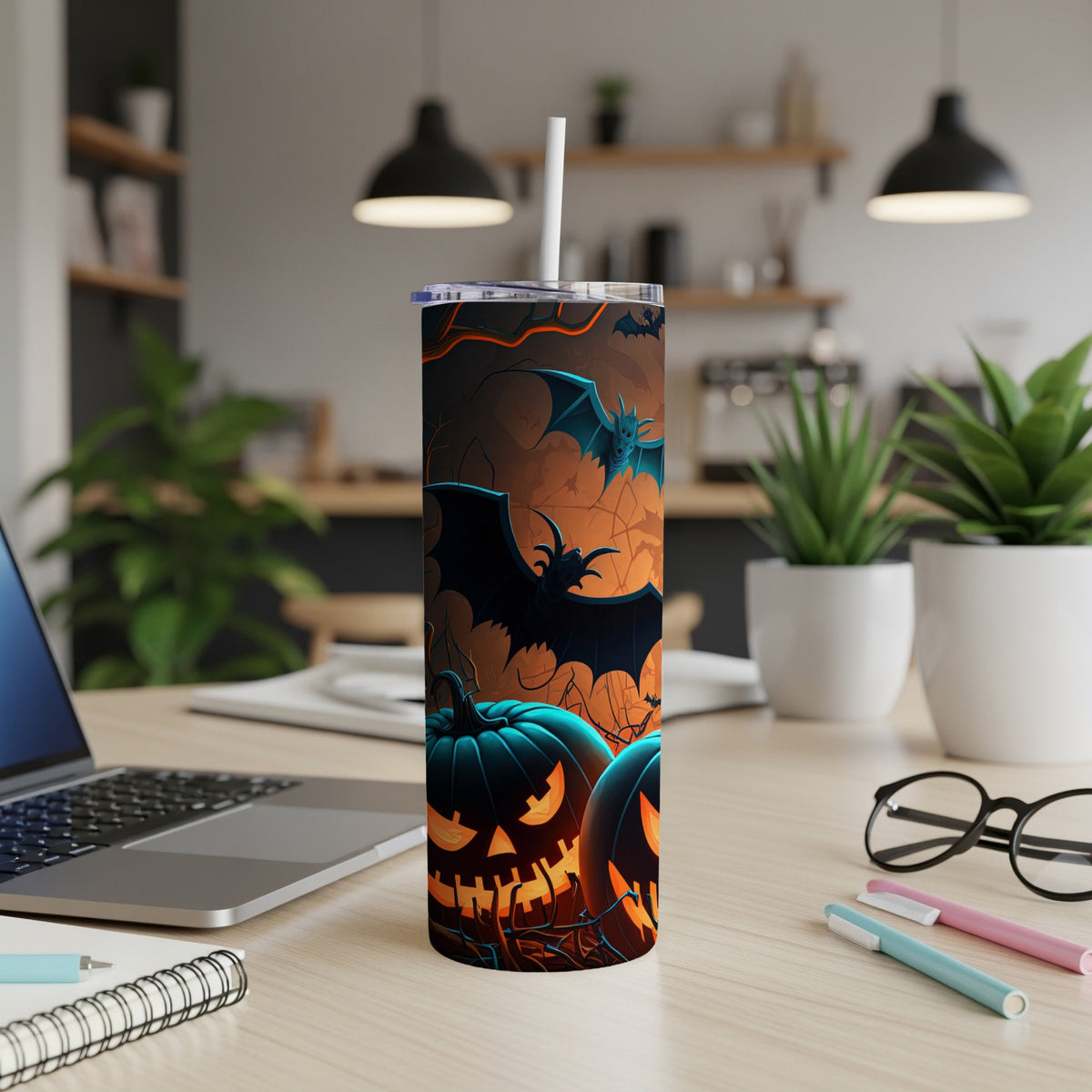 Tumbler with jack-o'-lanterns and bats, set on a desk.