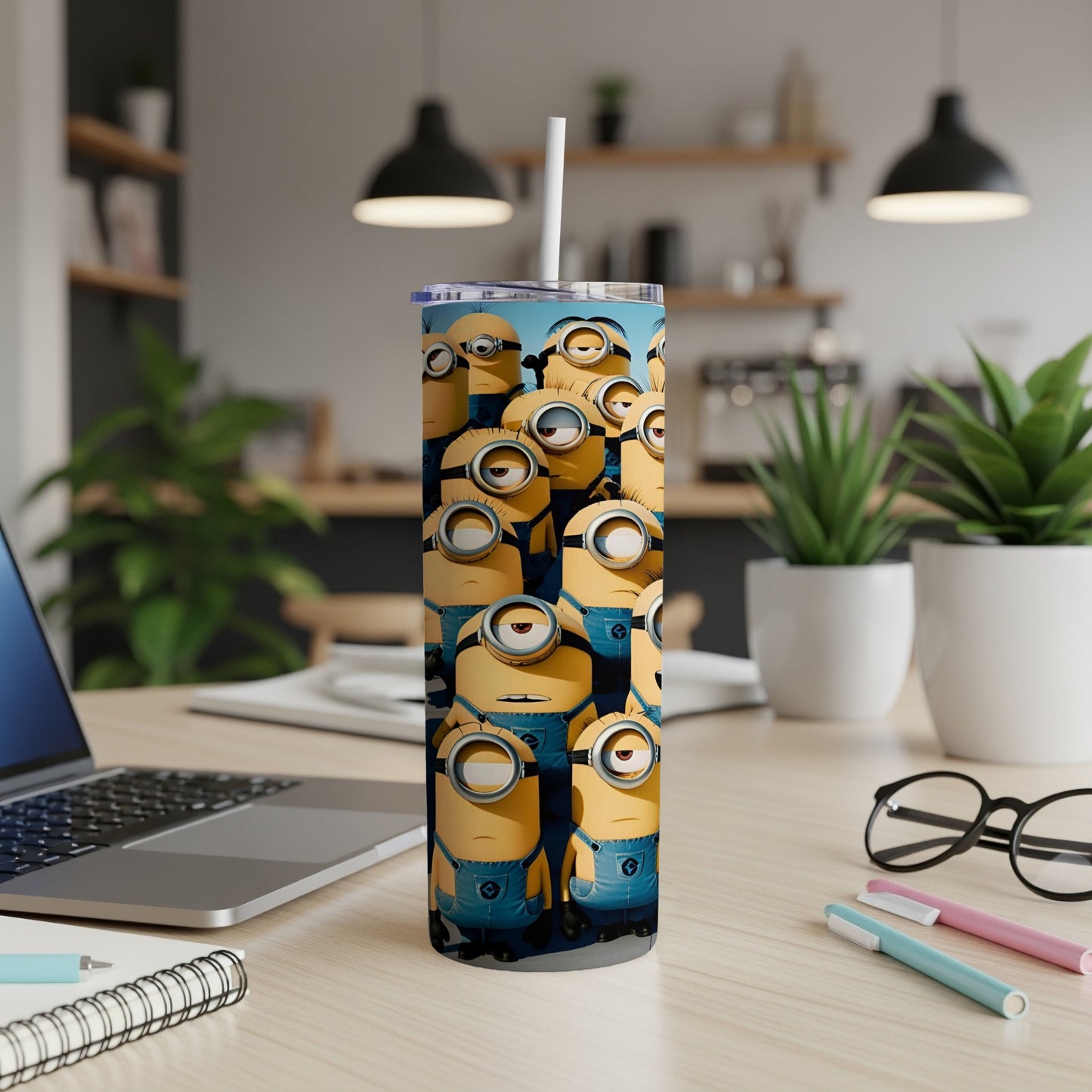 Minions characters on a blue tumbler with a straw, on a desk.