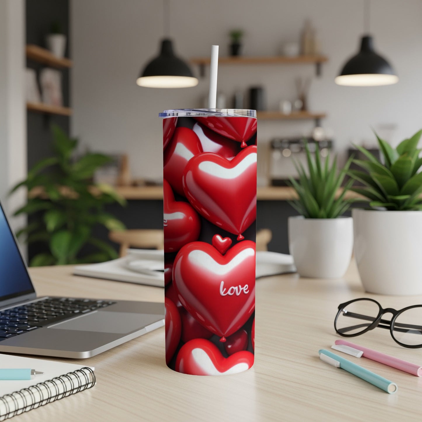Red heart tumbler with "Love" text, on a desk with a laptop.