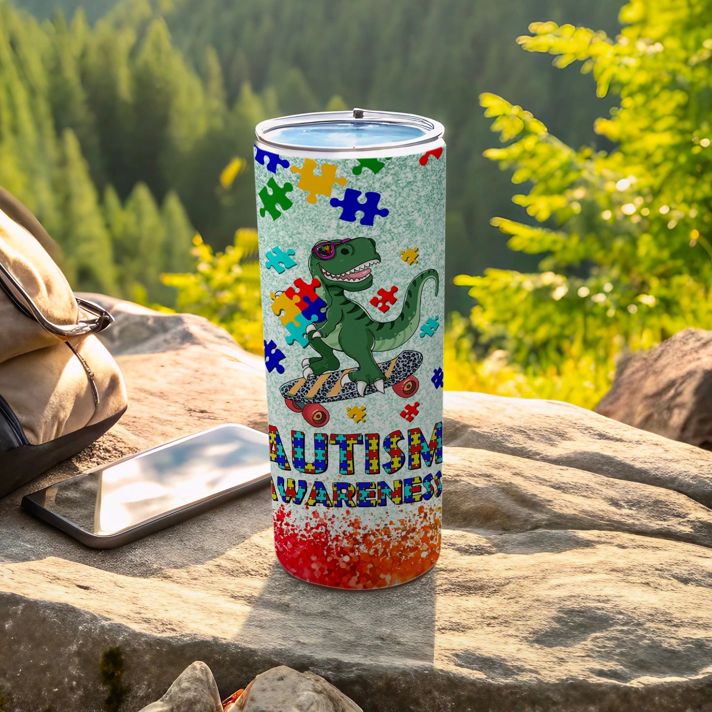 Autism awareness tumbler with colorful puzzle pieces, a skateboarding dinosaur, and textured background.