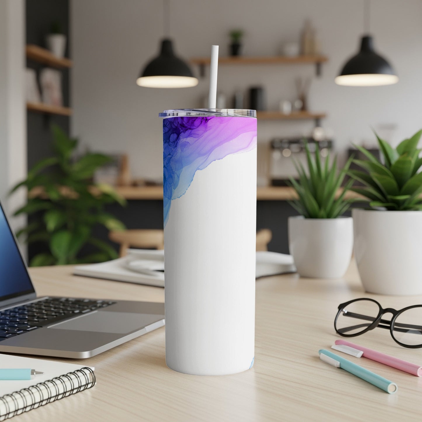 White tumbler with abstract blue and purple watercolor design and straw.