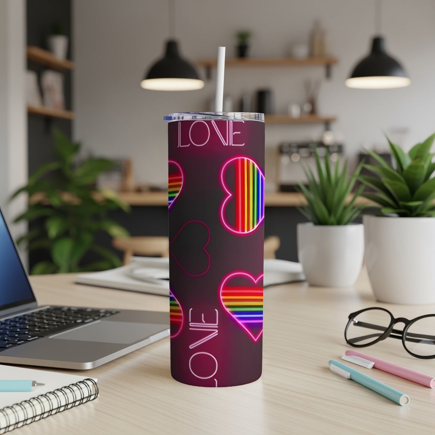 Rainbow heart "LOVE" graphic on a pink tumbler with a straw.