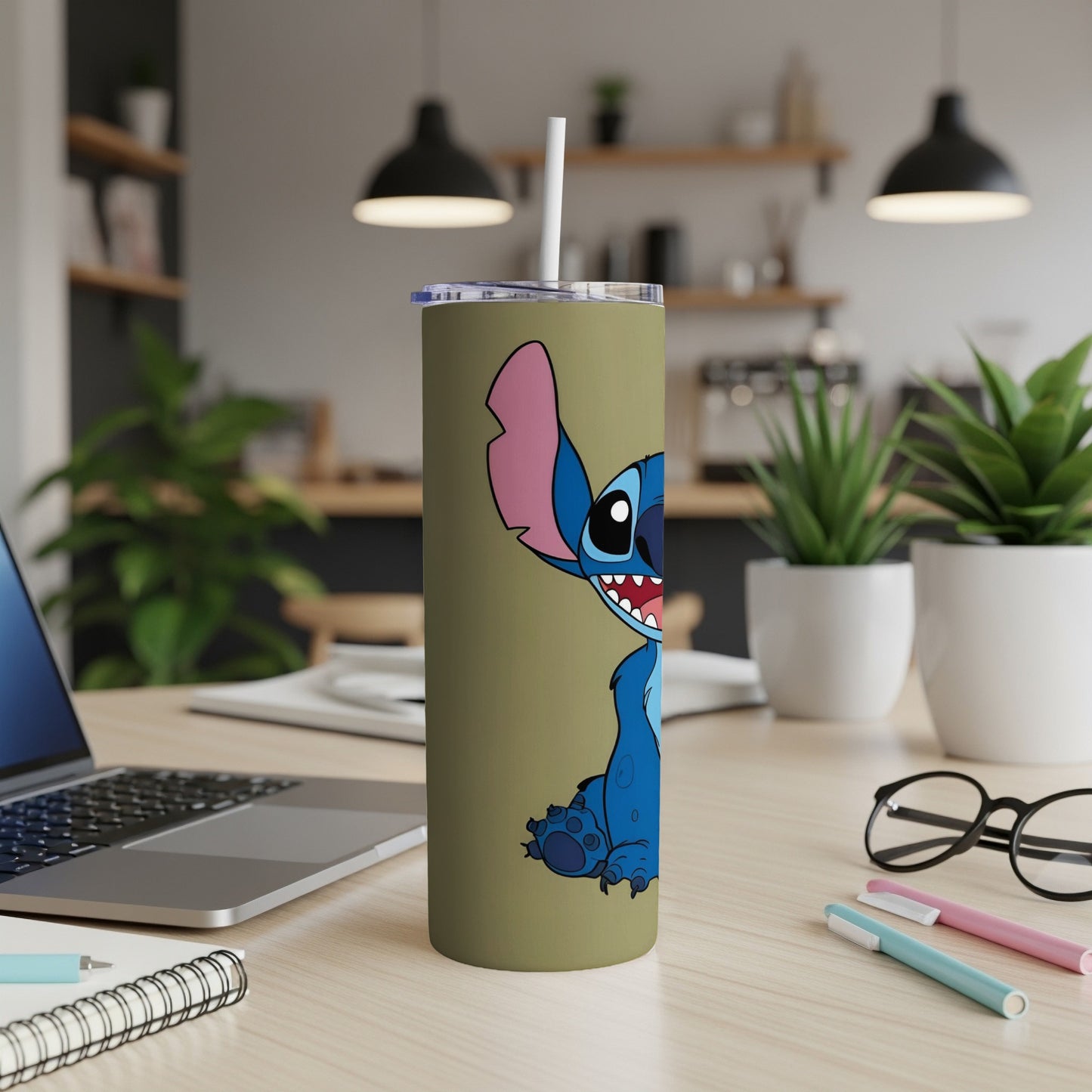 Stitch character on a tan tumbler with a straw, on a desk.