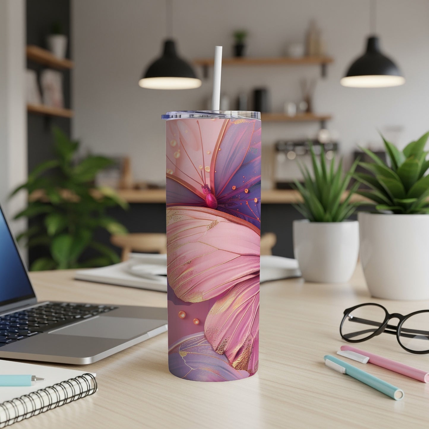 Pink and purple butterfly tumbler with gold accents on a desk.
