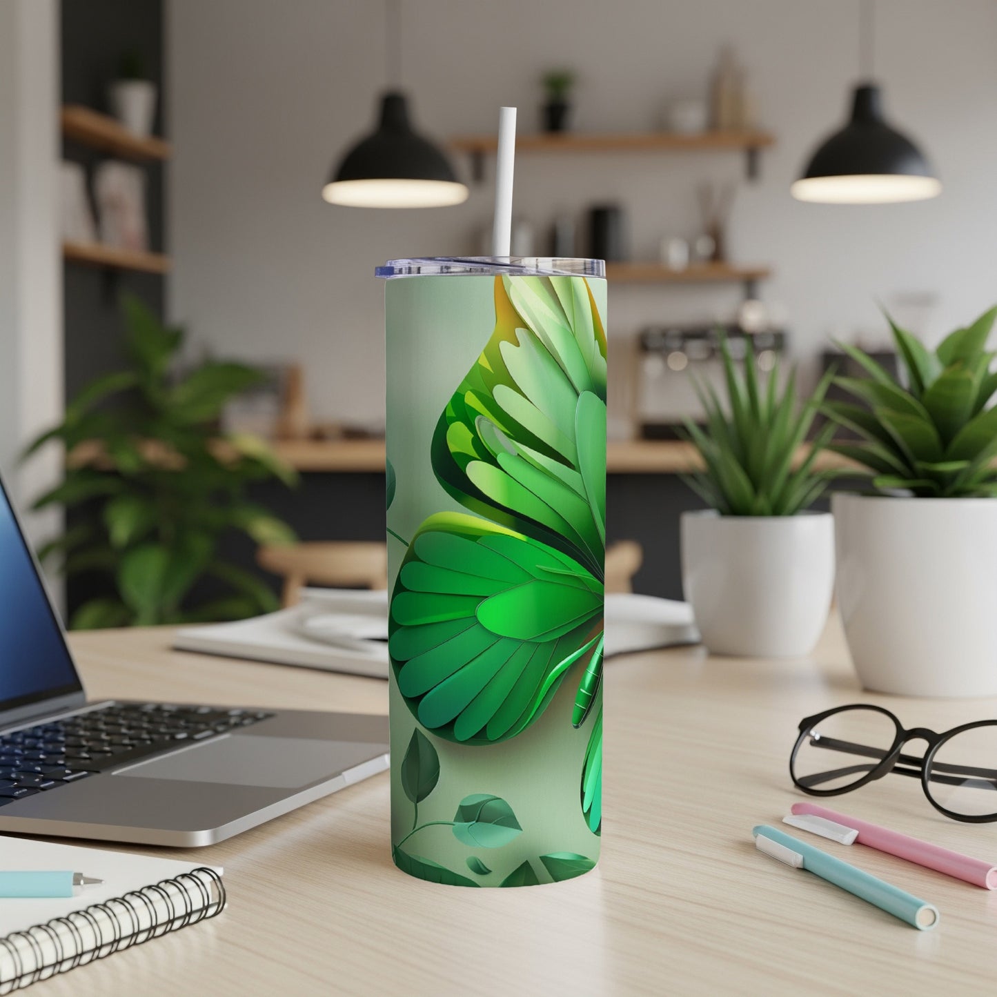 Green butterfly tumbler with straw on a desk.