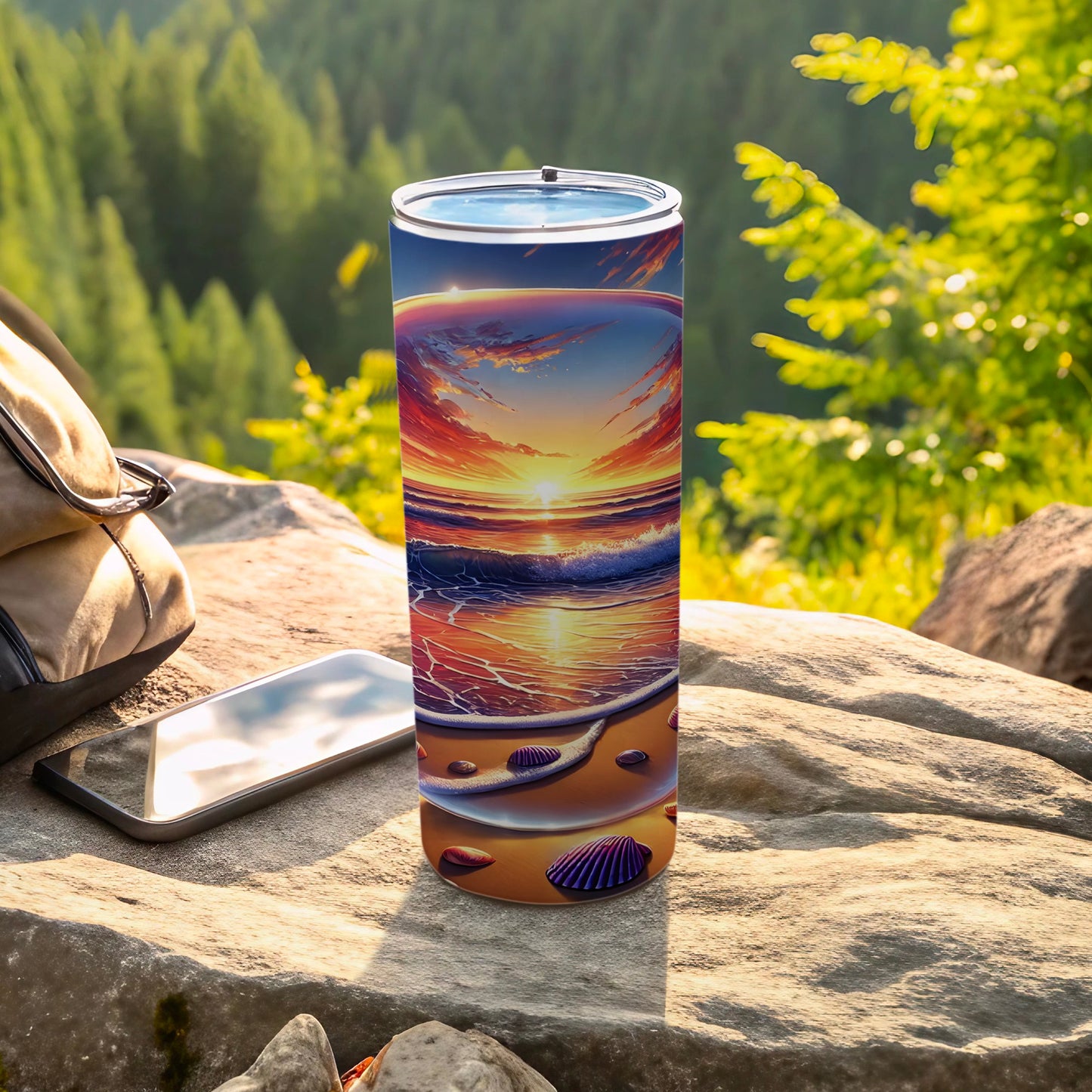 Tumbler with a sunset beach scene design sits on rocks.