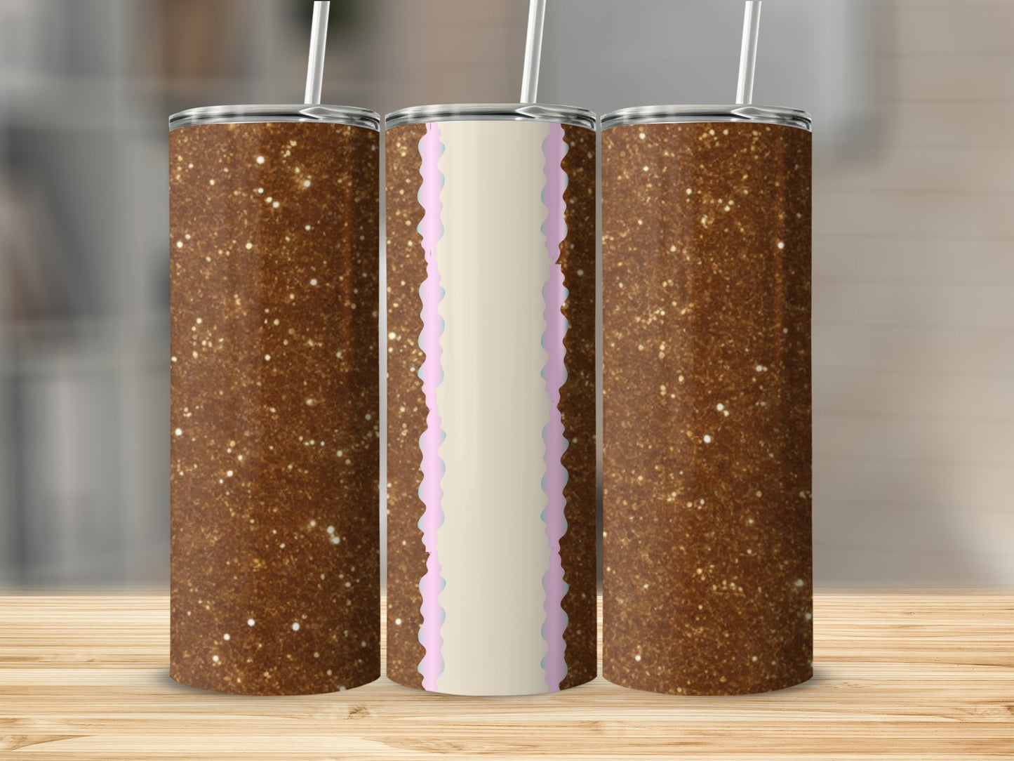 Three glitter tumblers with straws, two brown, one with pink and blue scalloped trim.