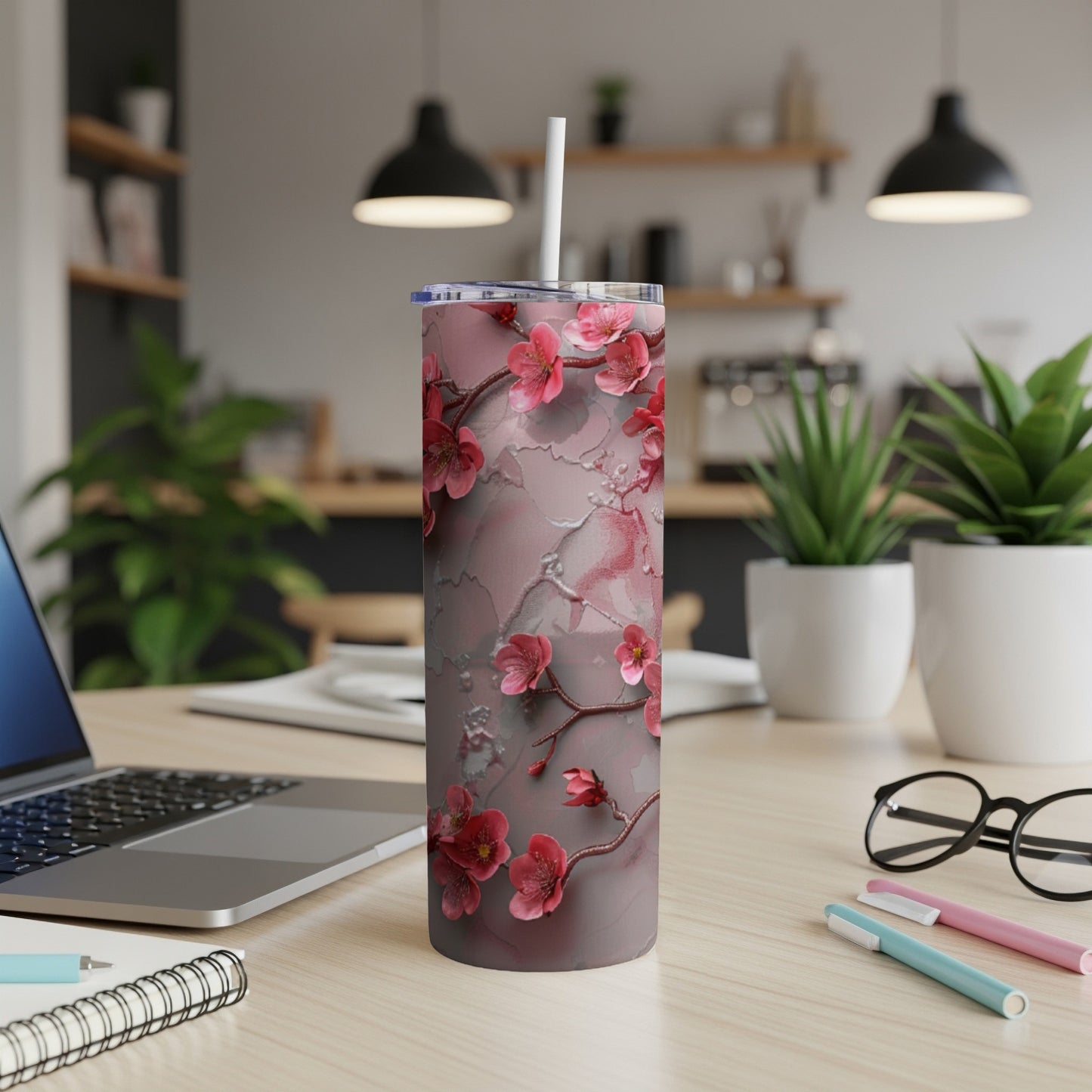 Pink floral design on a tall, slender tumbler with a straw.