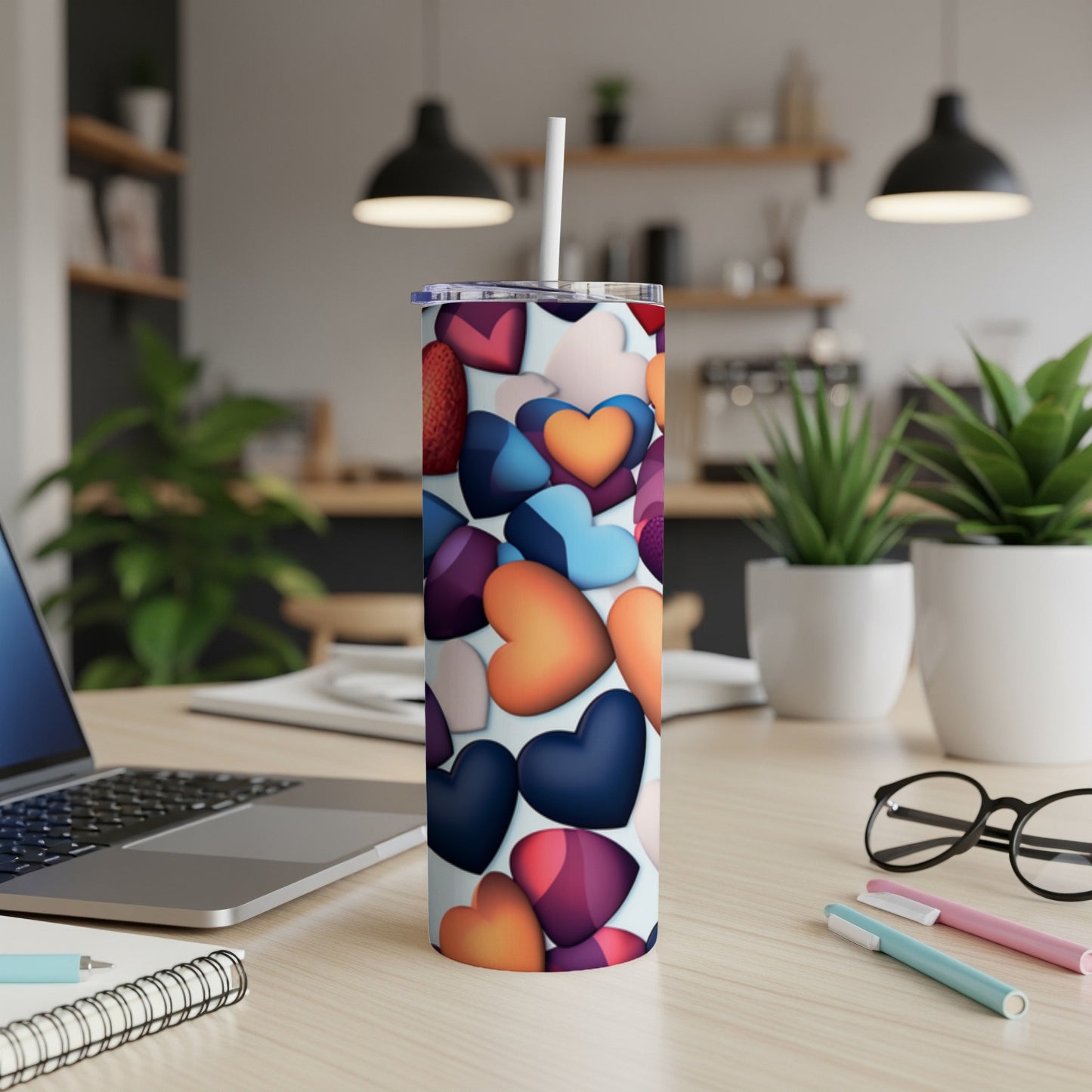 Tall tumbler with a colorful heart pattern on a desk.