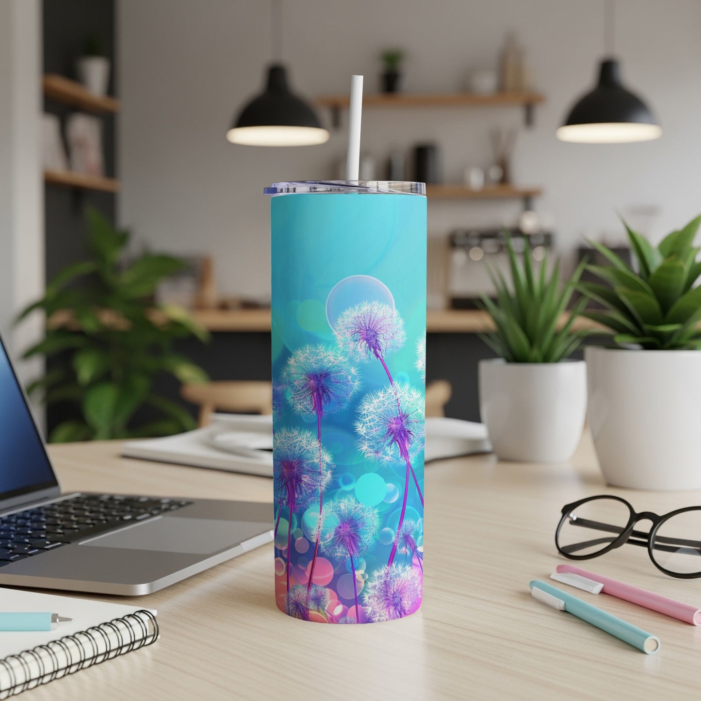 Turquoise tumbler with dandelions and bokeh effect, on a desk.