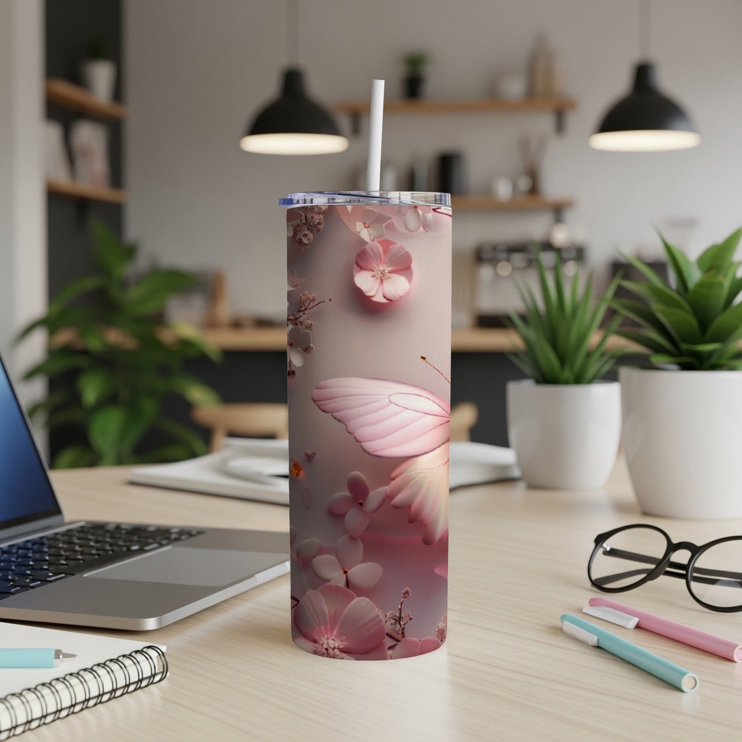 Pink butterfly and floral design on a stainless steel tumbler with straw.