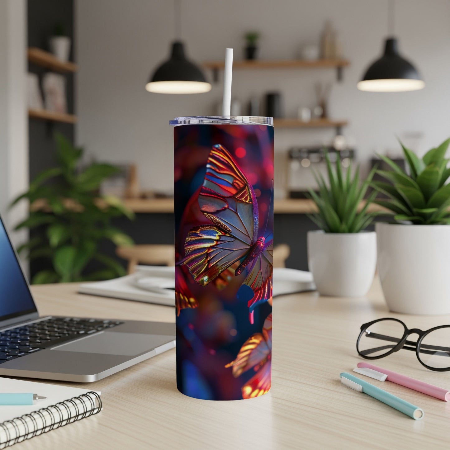 Colorful butterfly pattern on a white tumbler with straw, on a desk.