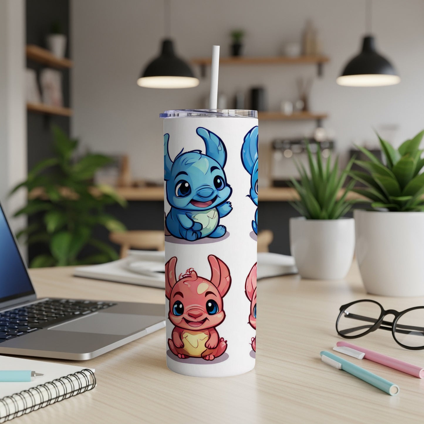Blue and pink cartoon creatures on a white tumbler with a straw.