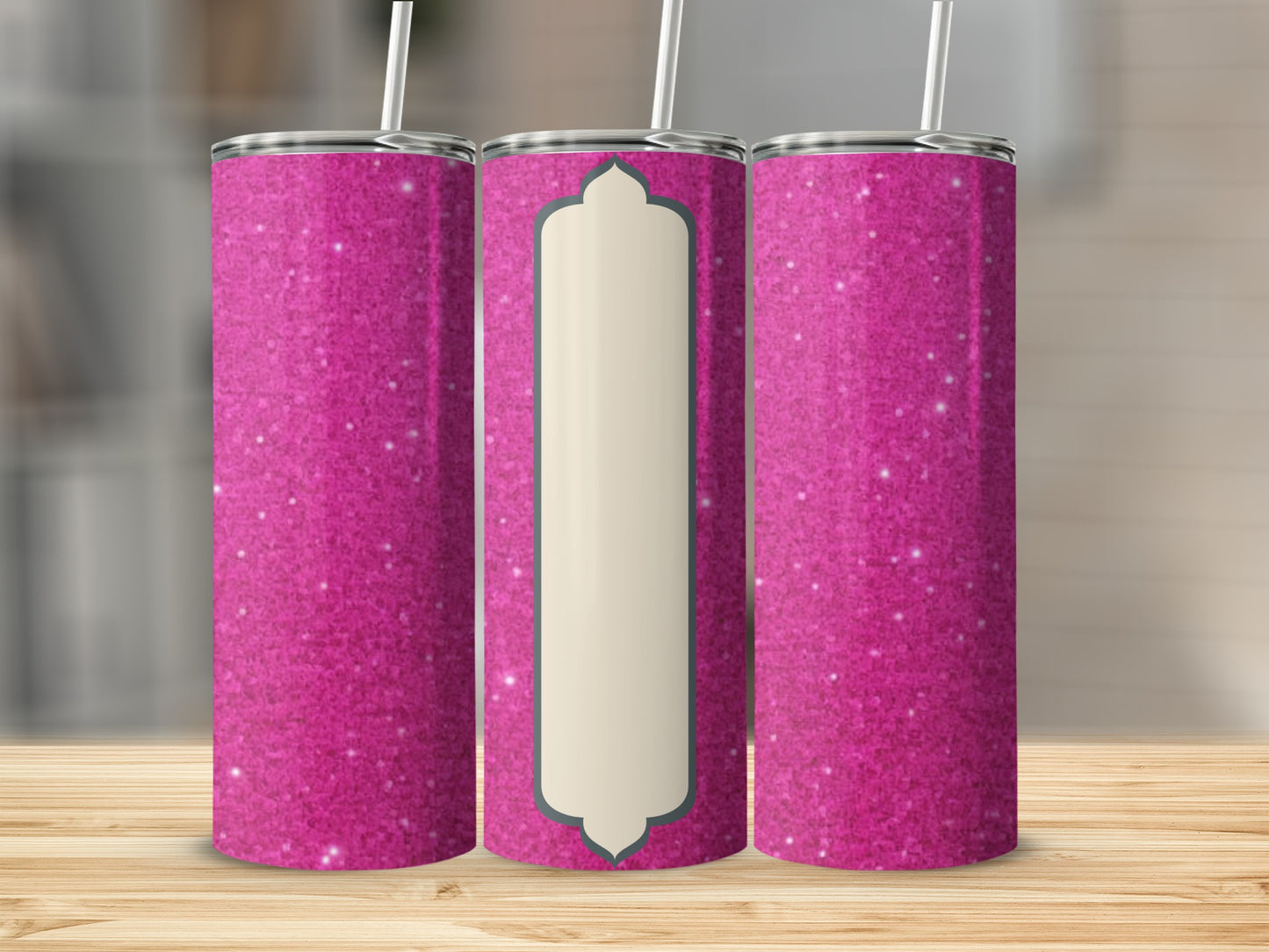 Three pink glitter tumblers with a central cream label on a wooden surface.