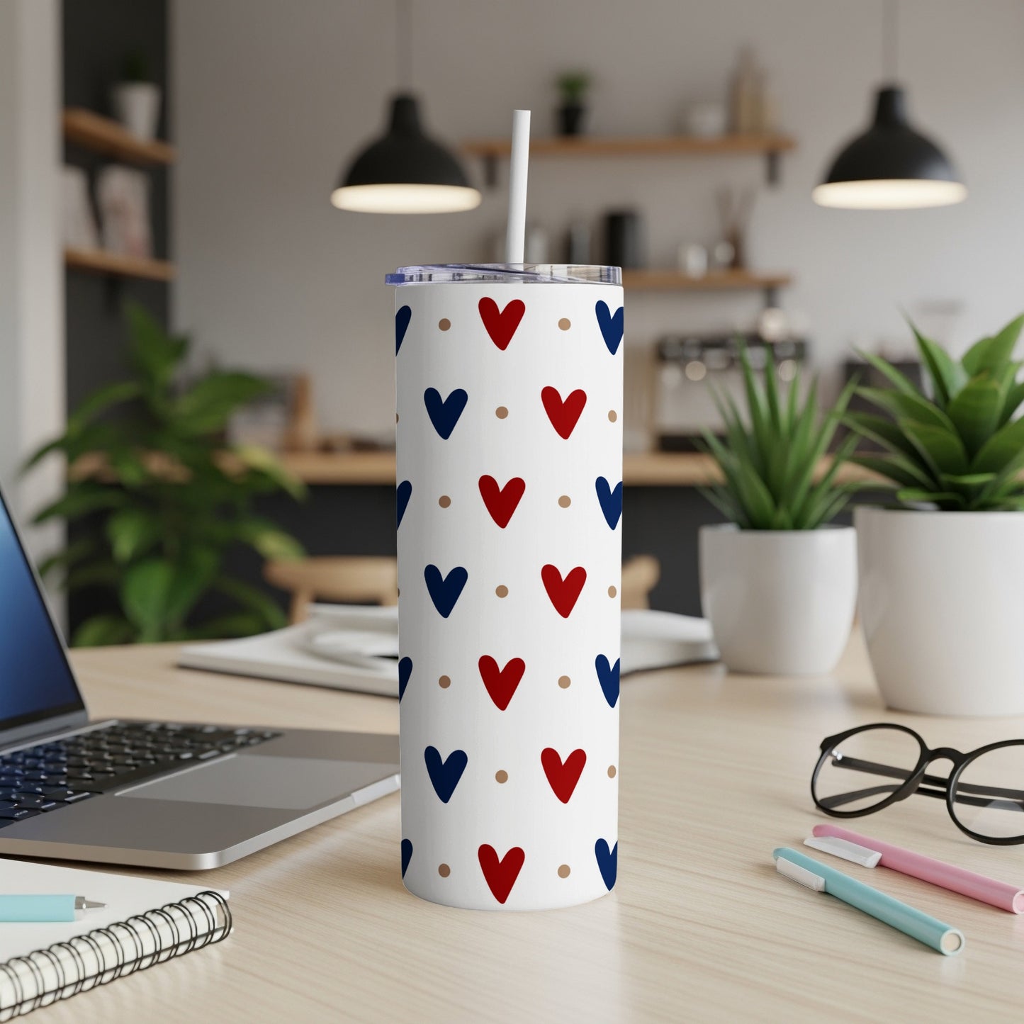 White tumbler with repeating red and blue heart pattern, straw.