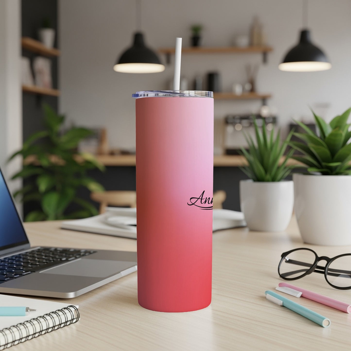 Pink gradient tumbler with "Ann" script on a wooden desk.