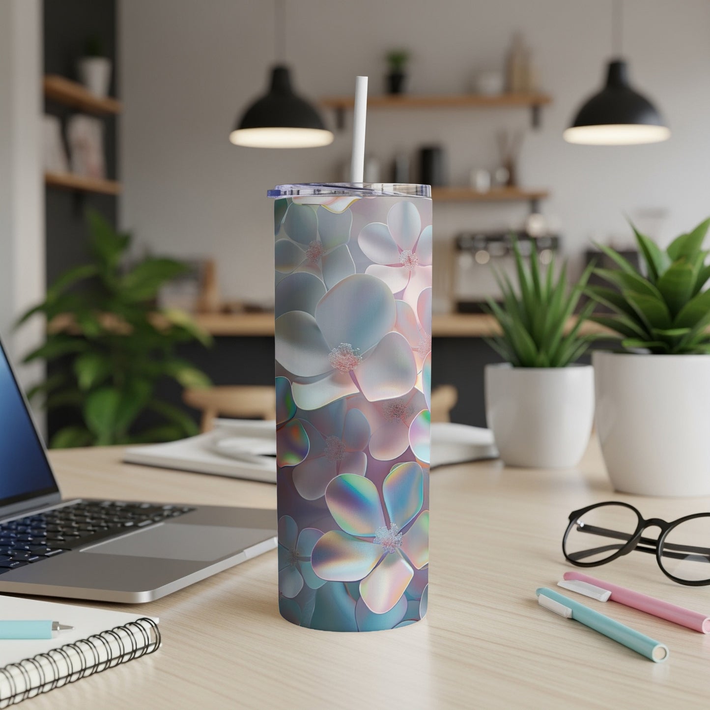 Iridescent floral print tumbler with straw on a desk.