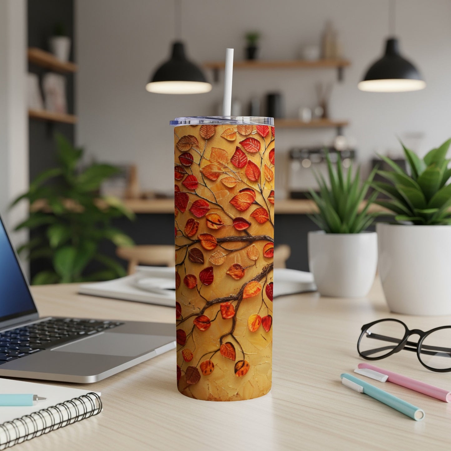 Textured tumbler with orange and red fall leaves on a branch.