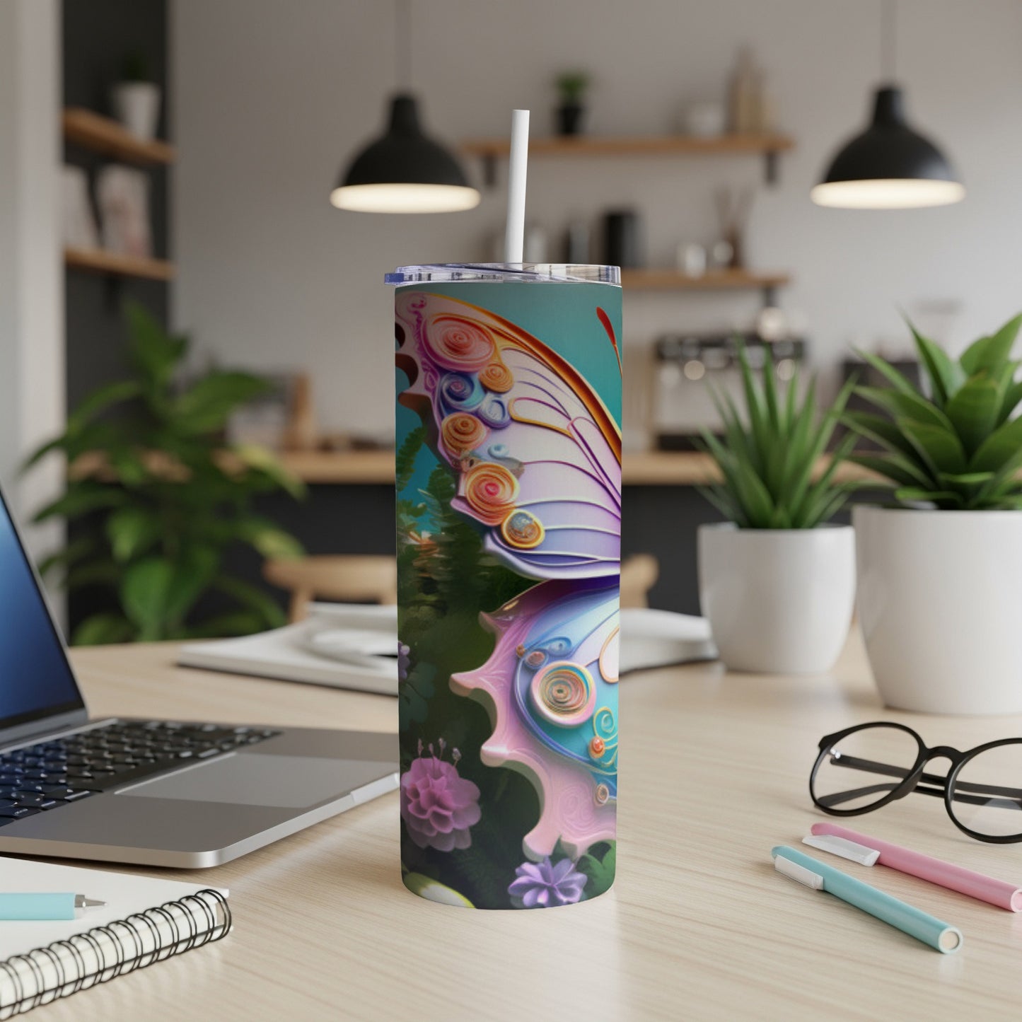 Tall tumbler with butterfly wing design, white straw, on wooden desk.