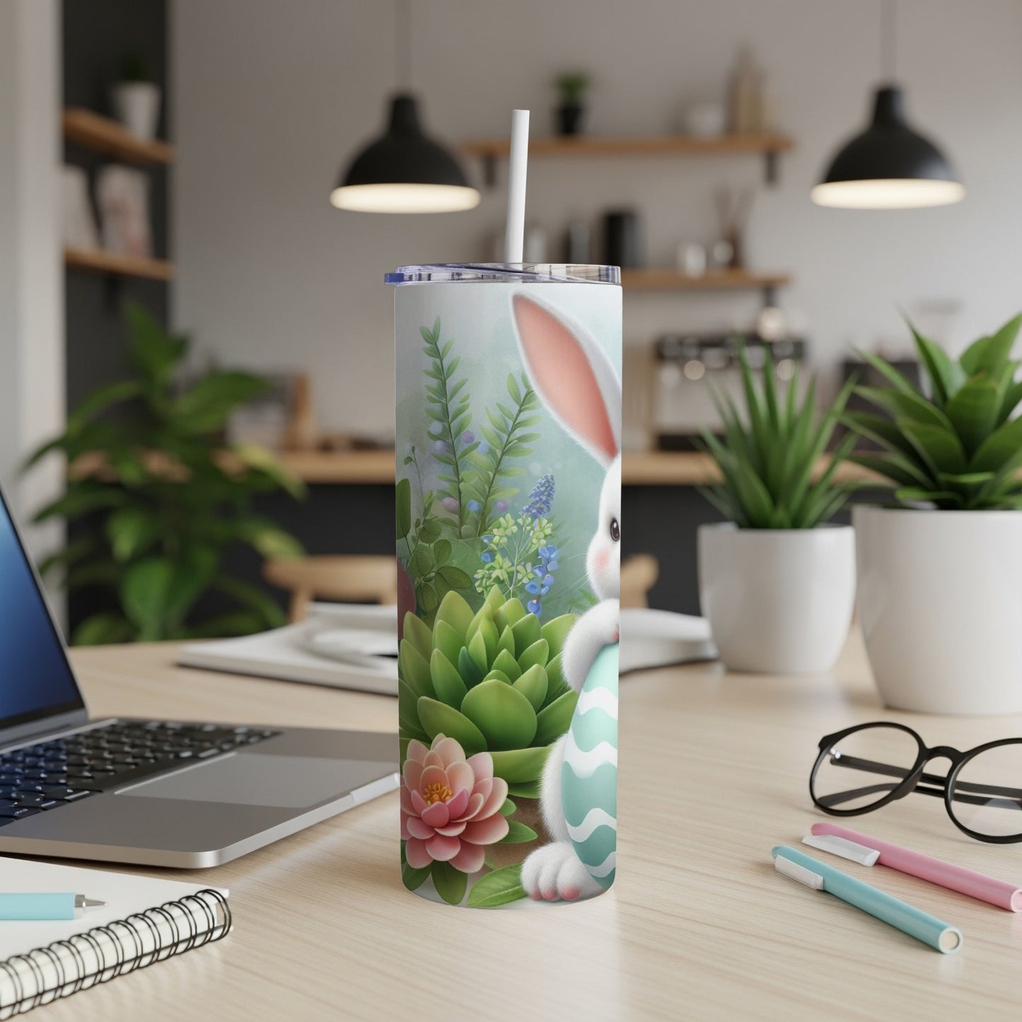 Easter bunny with an egg on a patterned tumbler with plants in background.