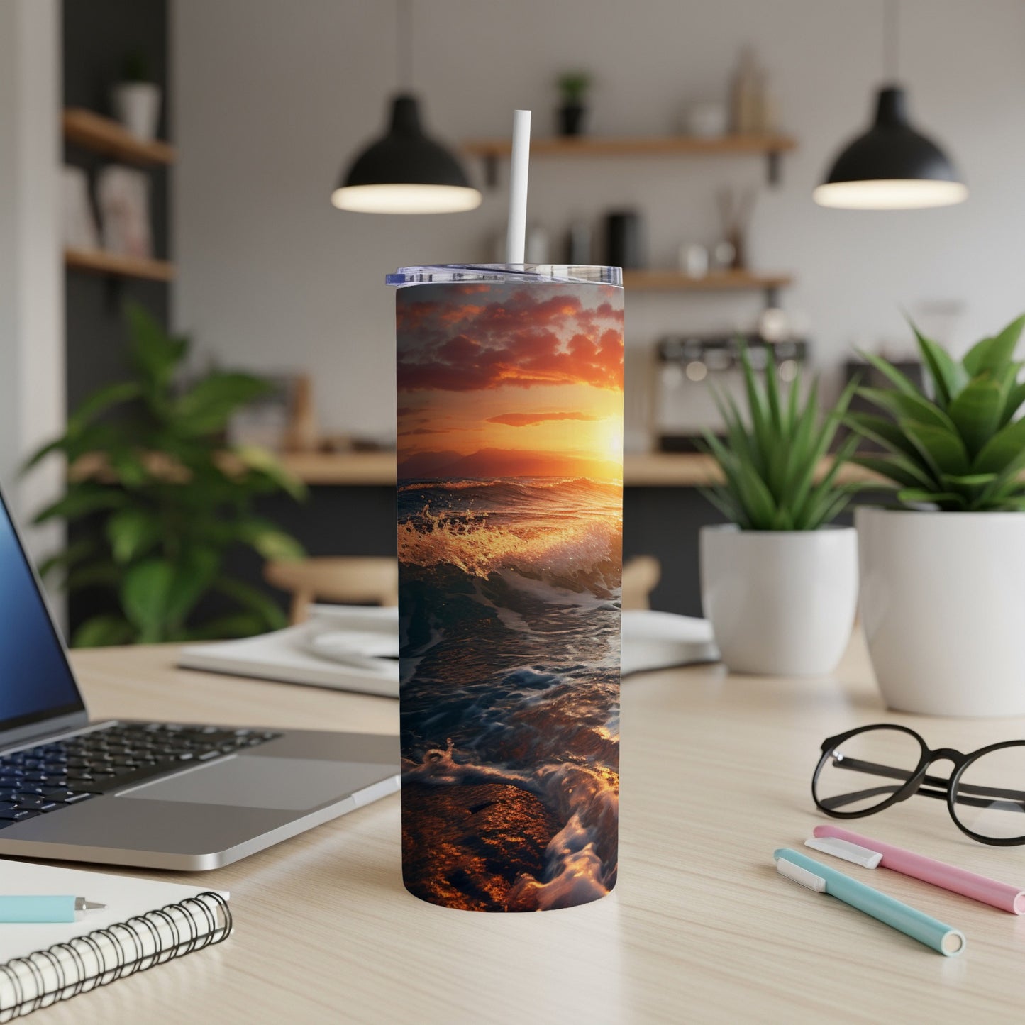 Sunset ocean waves crashing on shore, with a reusable tumbler on a desk.