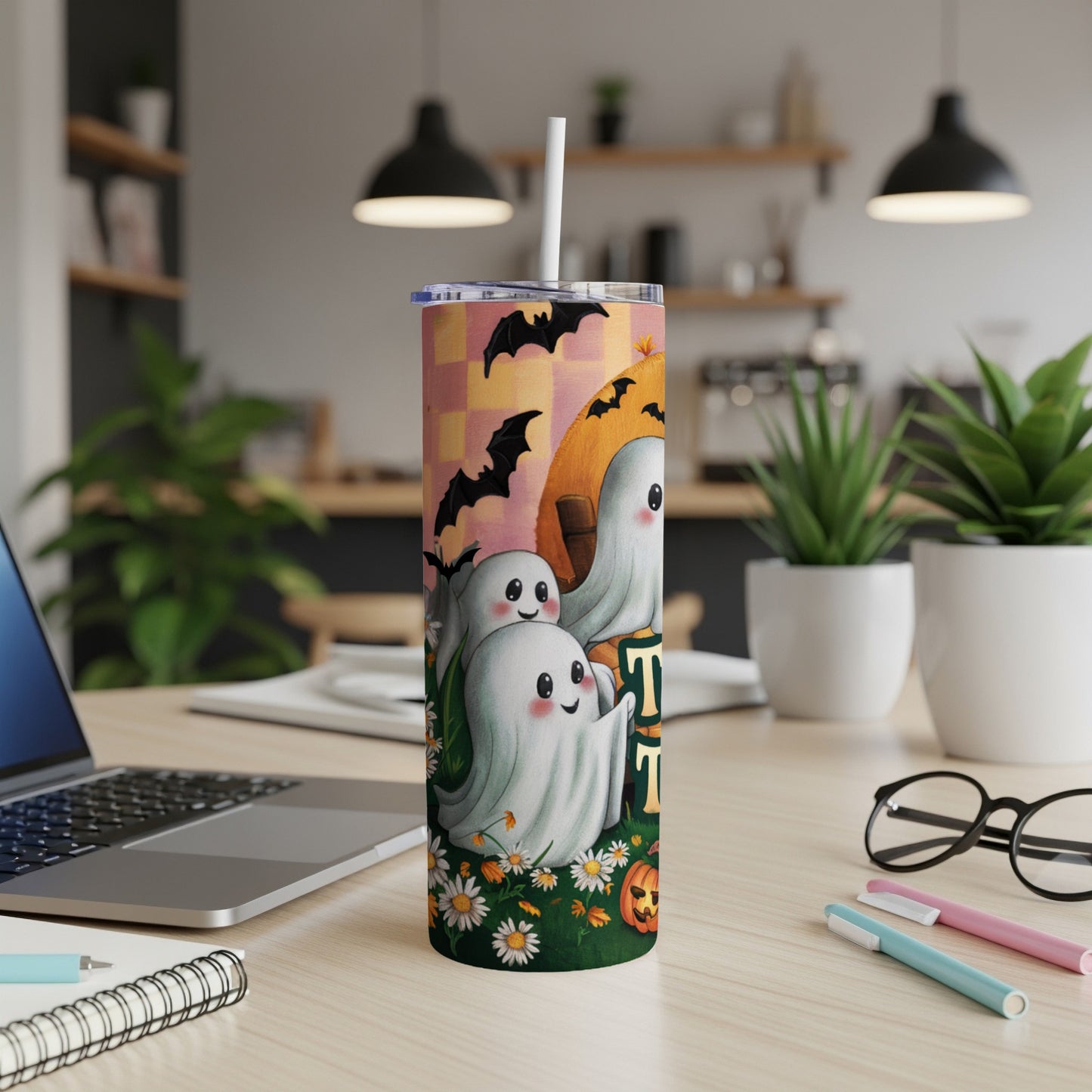 Halloween tumbler with cute ghosts, bats, and a pumpkin on a checkered background.