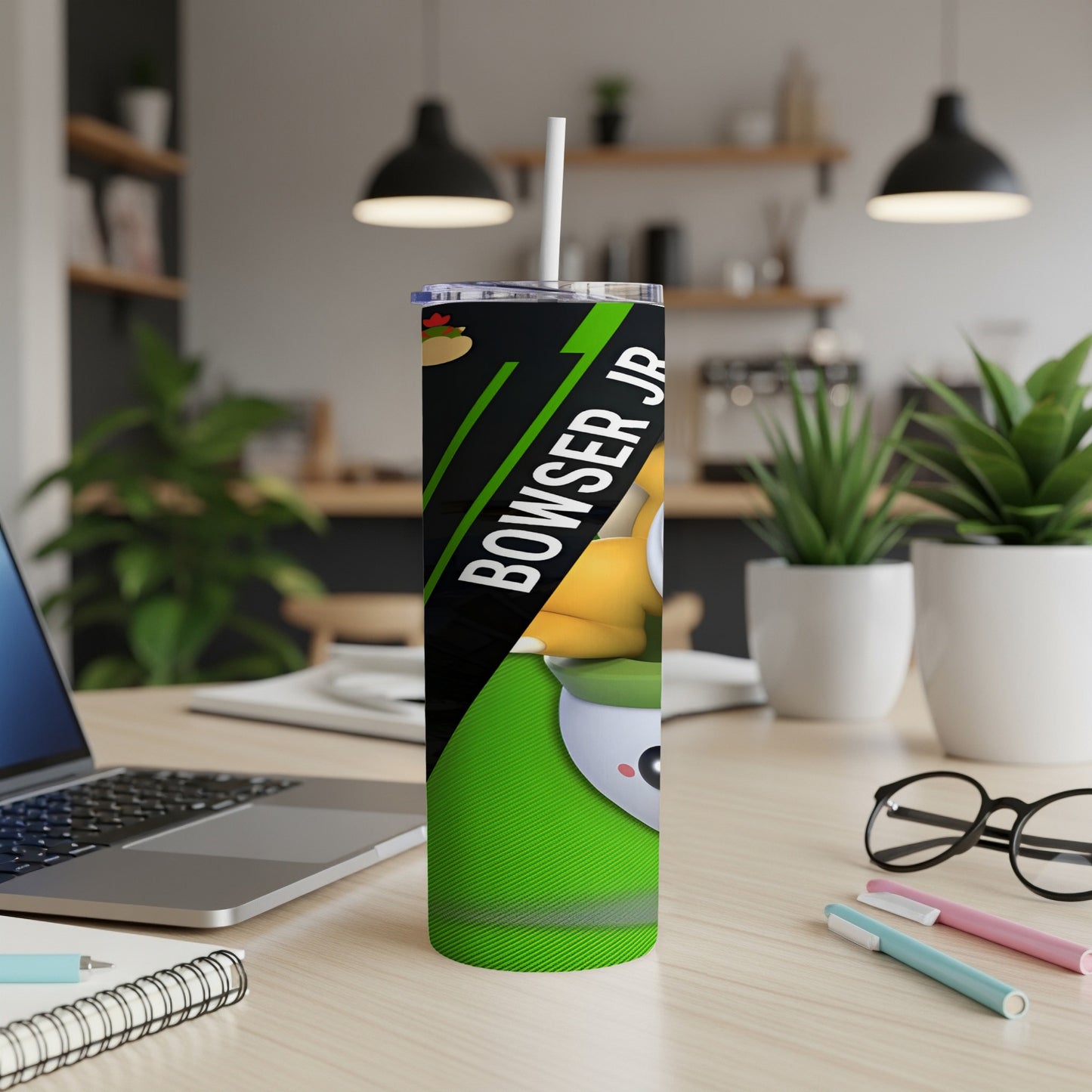 Green tumbler with Bowser Jr. design and white straw on a desk.