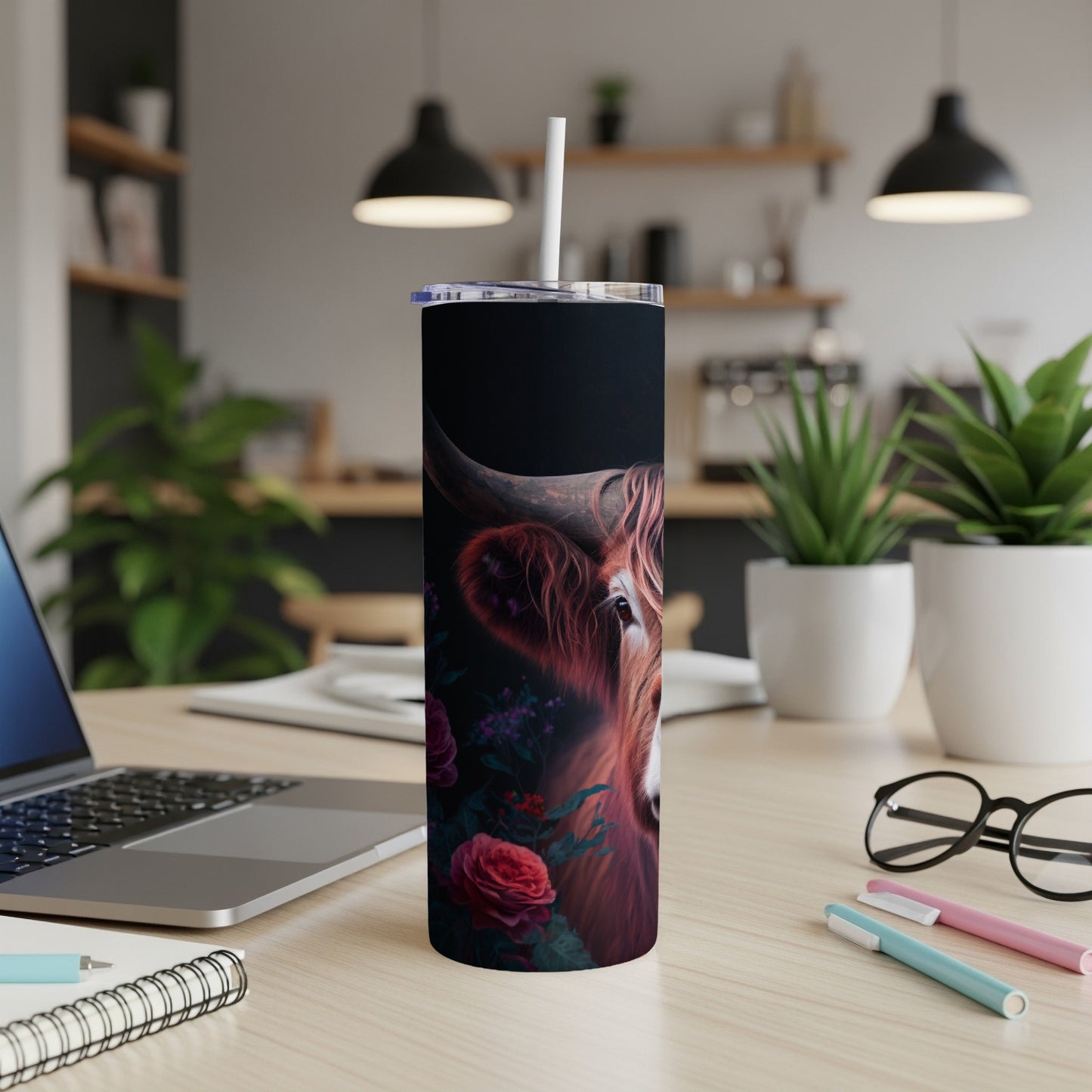 Highland cow and roses art on a black tumbler with a white straw.