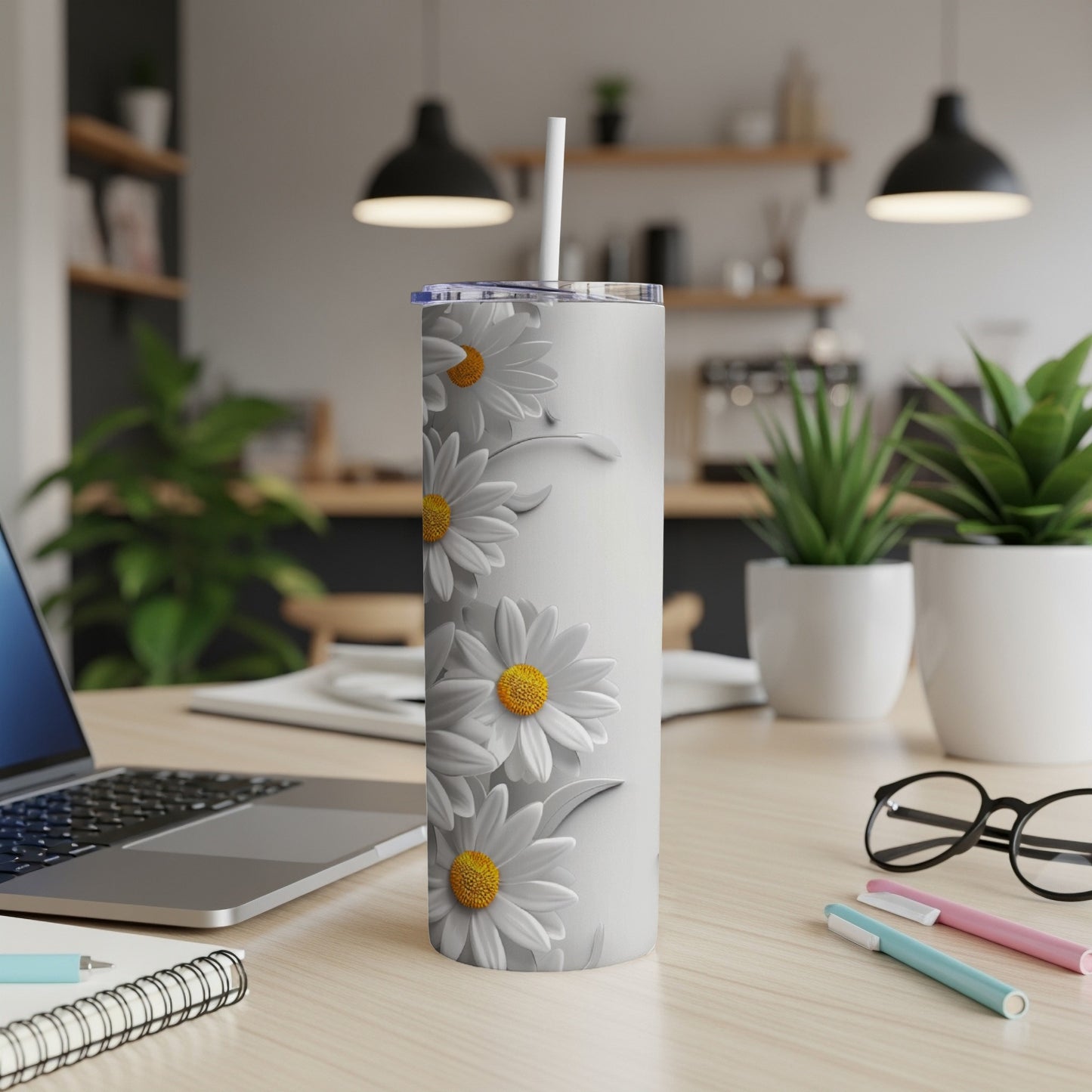 White tumbler with a repeating daisy floral pattern on a desk.