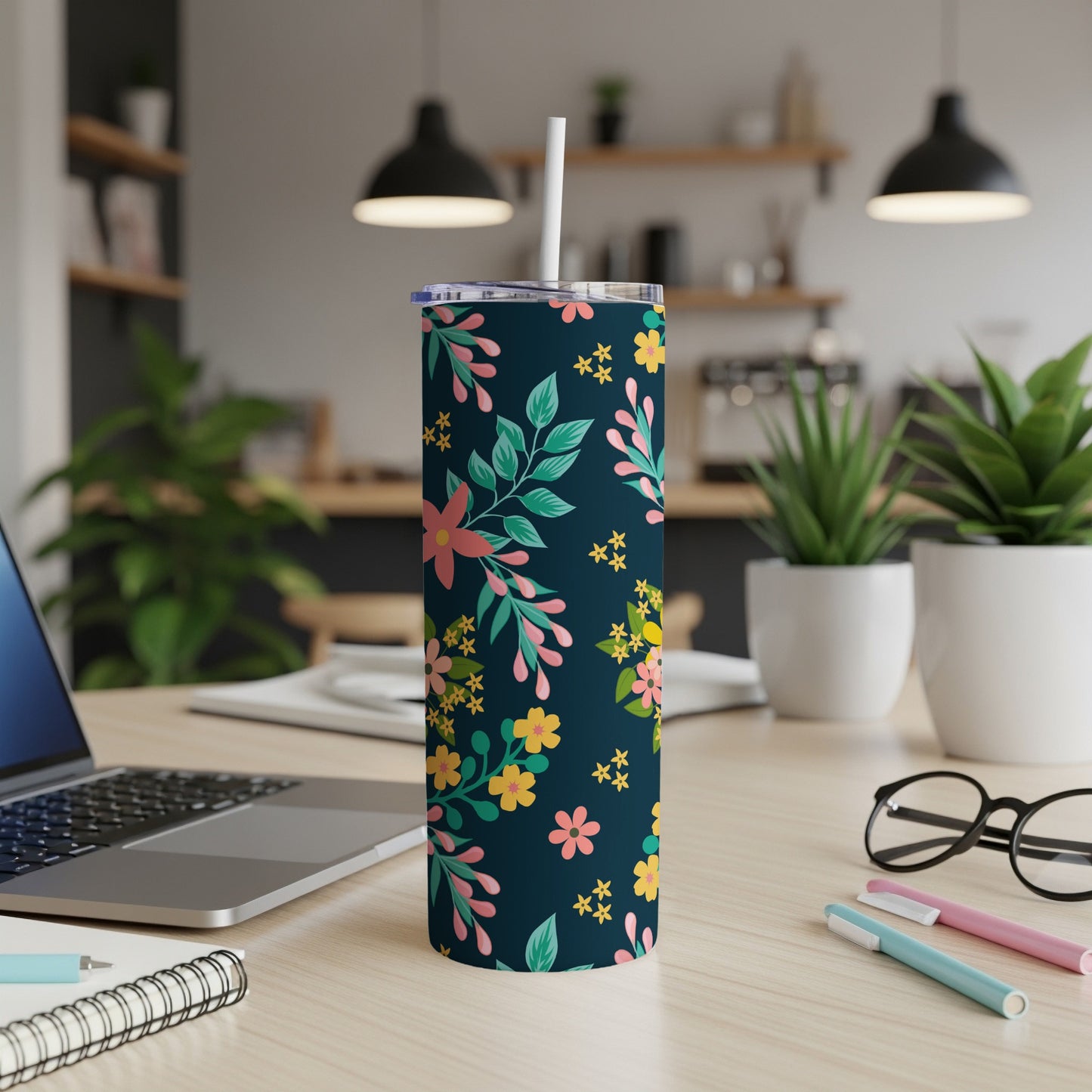 Dark blue tumbler with pink, yellow, and green floral pattern and white straw.